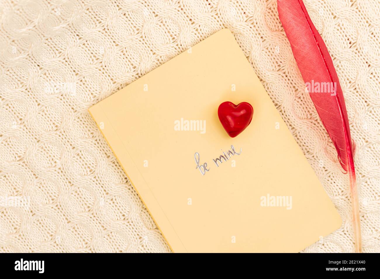 Valentinstag kreatives Konzept sein meine, Liebe Thema, Komposition mit Notizbuch, rotes Herz und farbige Feder Foto Stockfoto