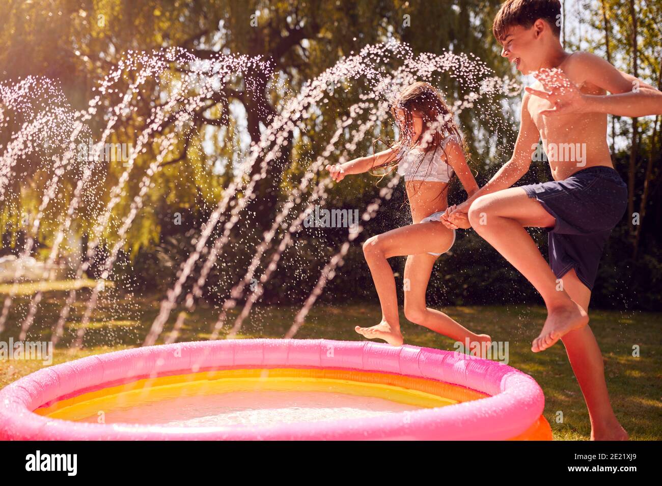 Kinder Tragen Badekostüme Mit Spaß Im Garten Spielen In Wasser Vom Gartensprinkler 