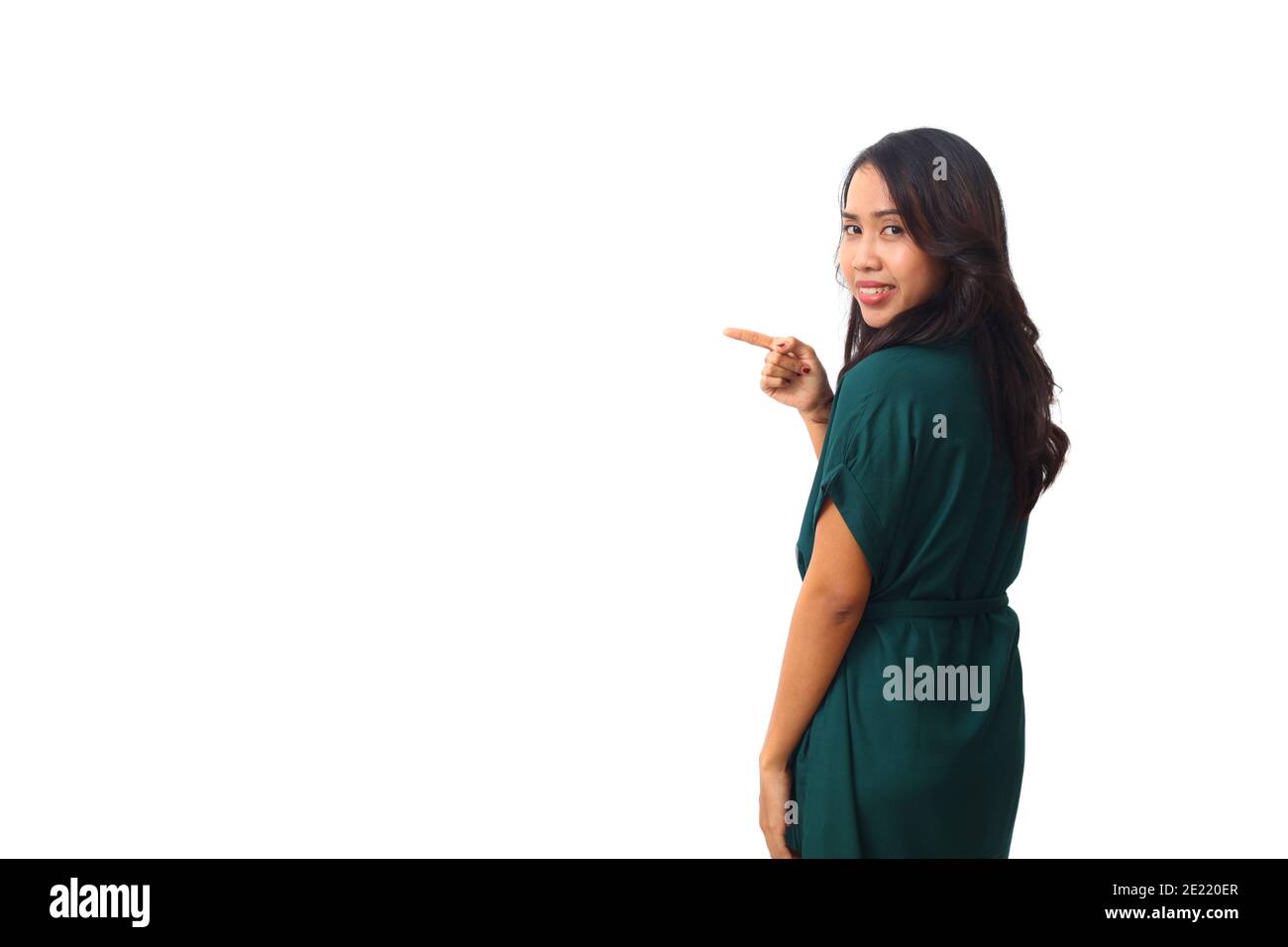 Portrait der schönen asiatischen Frau in grünem Kleid stehen, während präsentiert oder zeigt etwas neben ihr. Isoliert auf weißem Hintergrund mit Copyspa Stockfoto