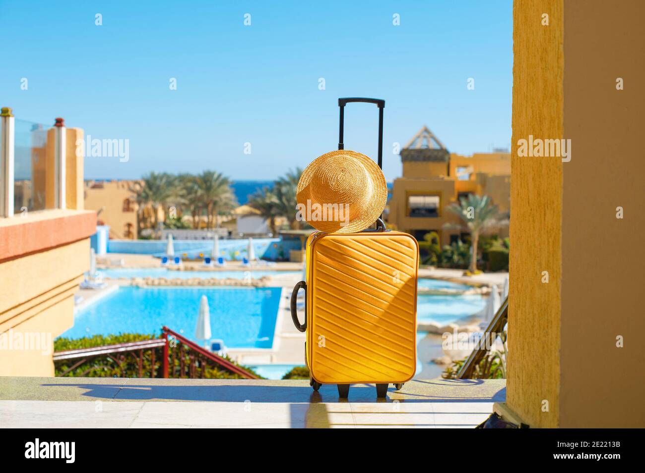 Reise, Sommerferien und Urlaubskonzept gelben Koffer mit Hut auf dem Hintergrund des Hotel-Pool-Bereich in Ägypten Stockfoto Reise, Sommerferien und Urlaubskonzept gelben Koffer mit Hut auf dem Hintergrund des Hotel-Pool-Bereich in Ägypten Stockfoto