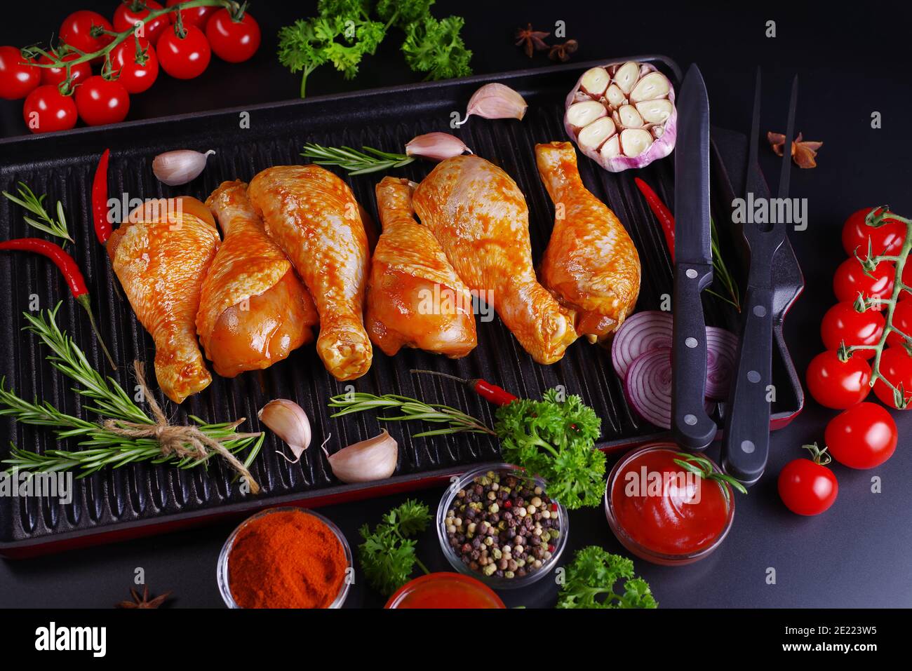 Ogranic Food und gesunde Ernährung Konzept.marinierte Huhn Dramstick auf einer Grillpfanne mit Gewürzen zum Kochen. Stockfoto