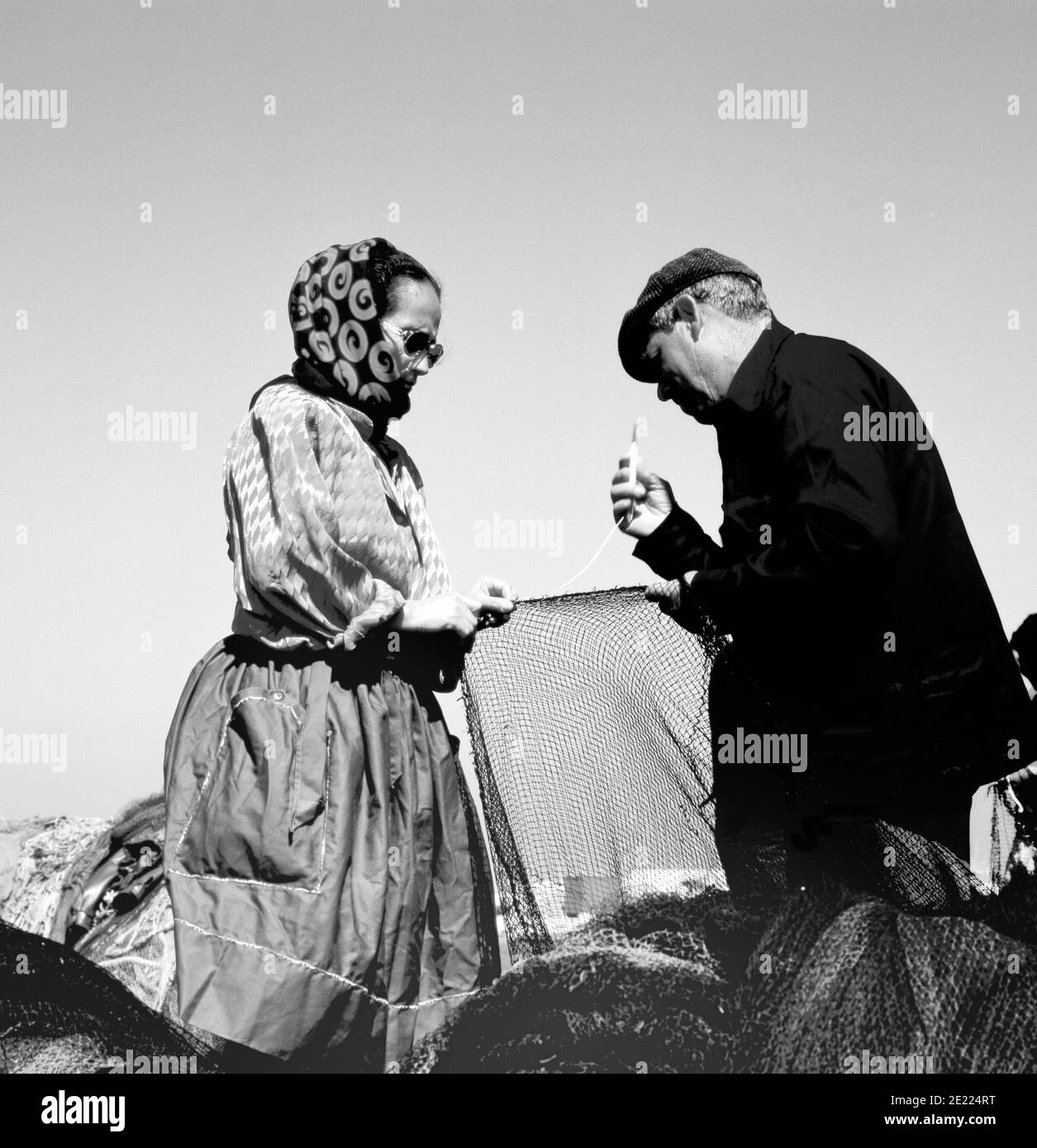 NAZARE, PORTUGAL-SEPTEMBER 18,1981:Fischer und seine Frau flicken Netze auf die alte traditionelle Weise Stockfoto