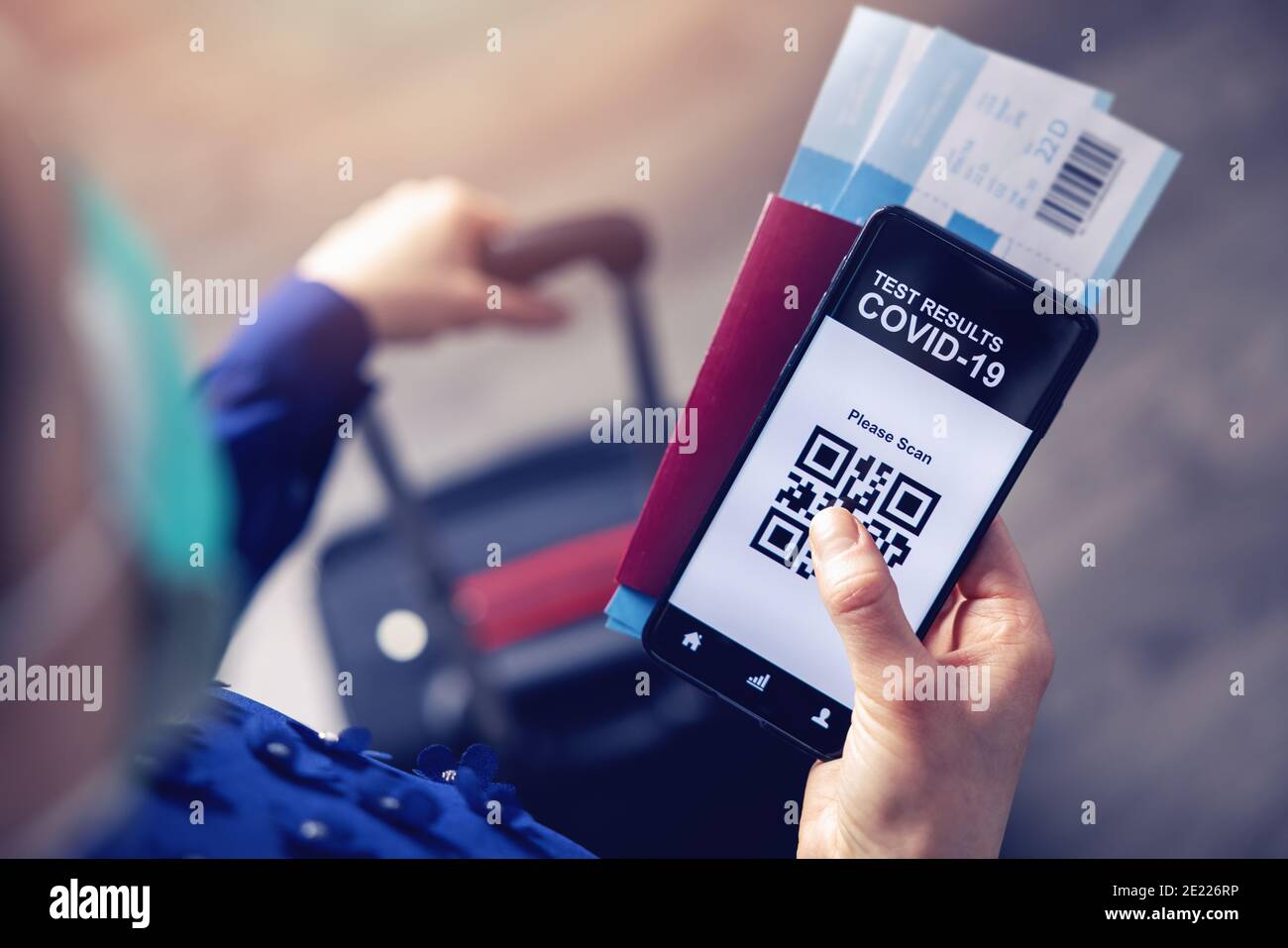 Person am Flughafen, die die mobile App im Telefon verwendet, um sie anzuzeigen Covid-19 Testergebnisse für Reisen Stockfoto