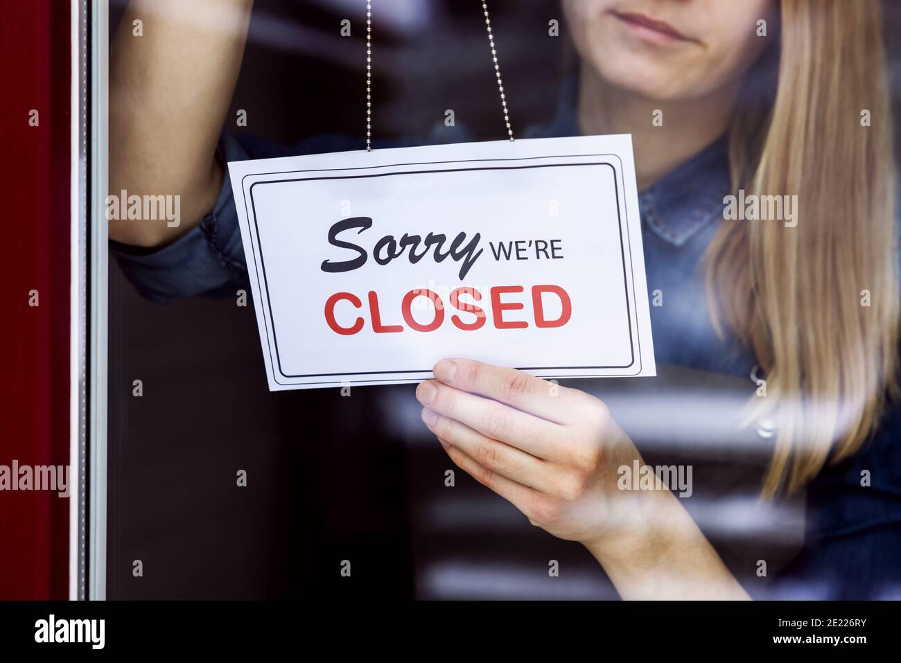 Frau hängend geschlossen Schild an kleinen lokalen Geschäft Shop Tür Angezeigt Stockfoto