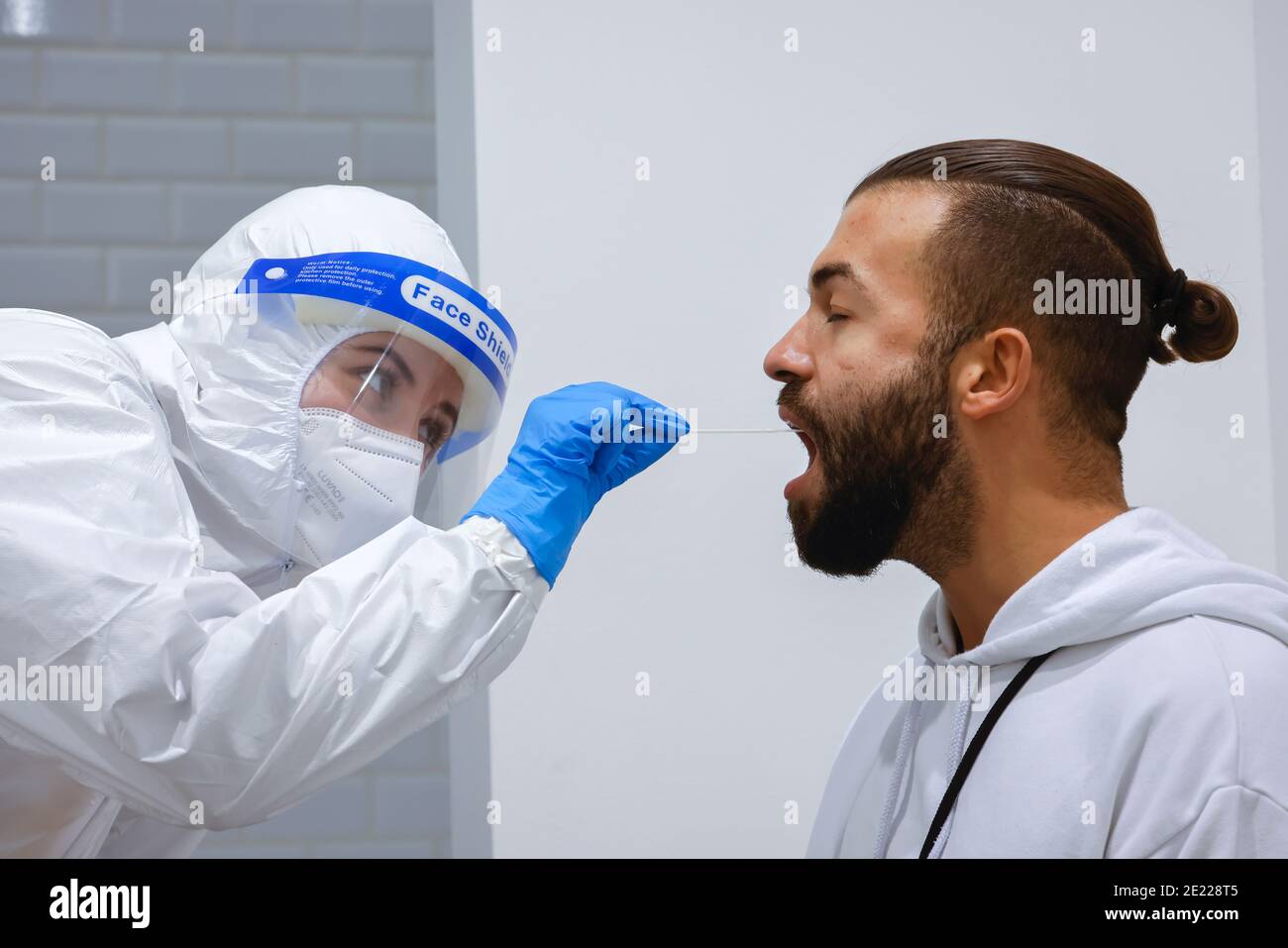 Köln, Nordrhein-Westfalen, Deutschland - Covid-Schnelltest im Medicare-Testzentrum, Rachenabstrich auf Wattestäbchen - Modell freigegeben - Stockfoto