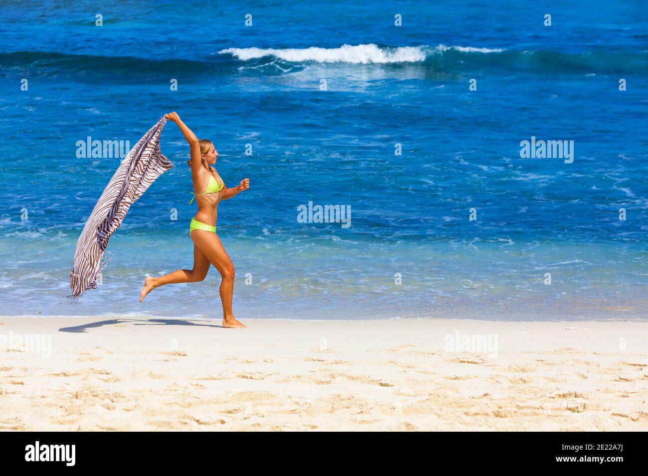 Glückliche Familie haben Spaß am tropischen Meer Strand Resort. Lustige junge Frau im Bikini laufen mit Spritzern am Wasserpool entlang der Surfkante. Aktiver Lebensstil Stockfoto