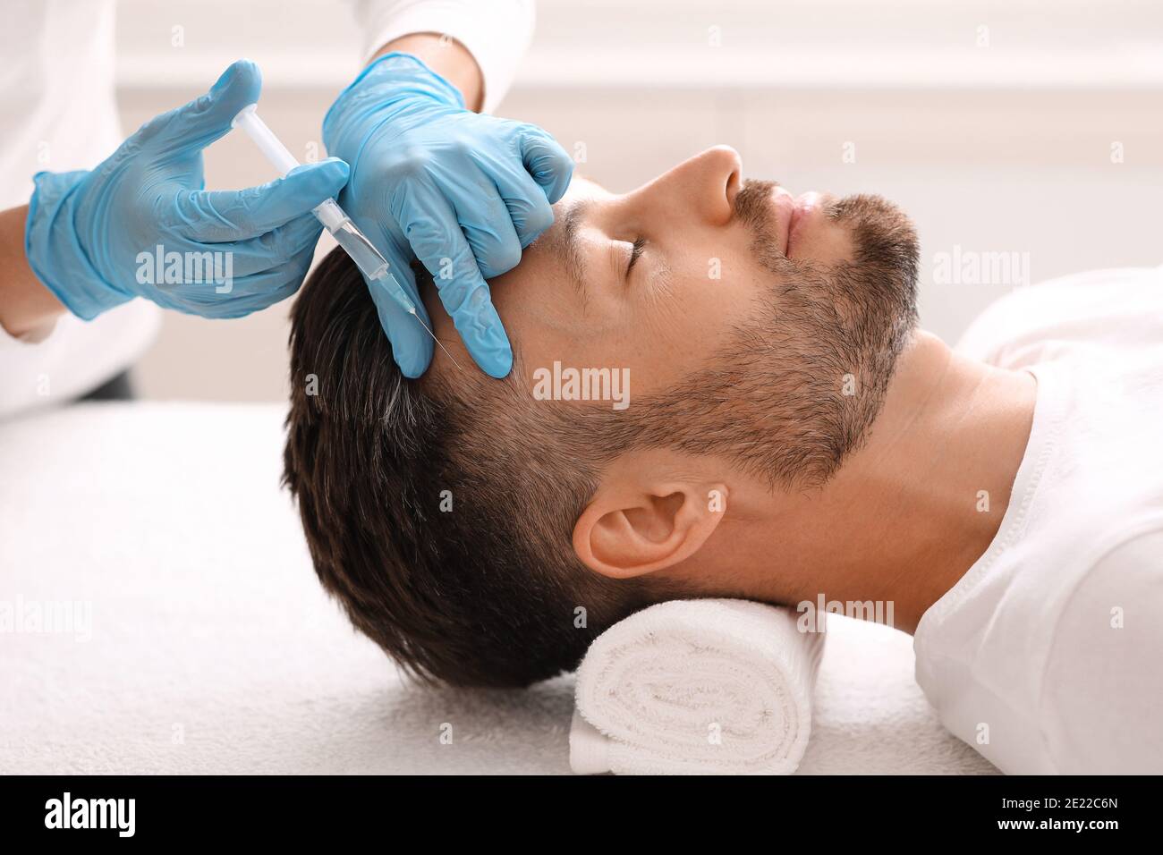 Mann mittleren Alters mit Haarbehandlung im Schönheitssalon Stockfoto