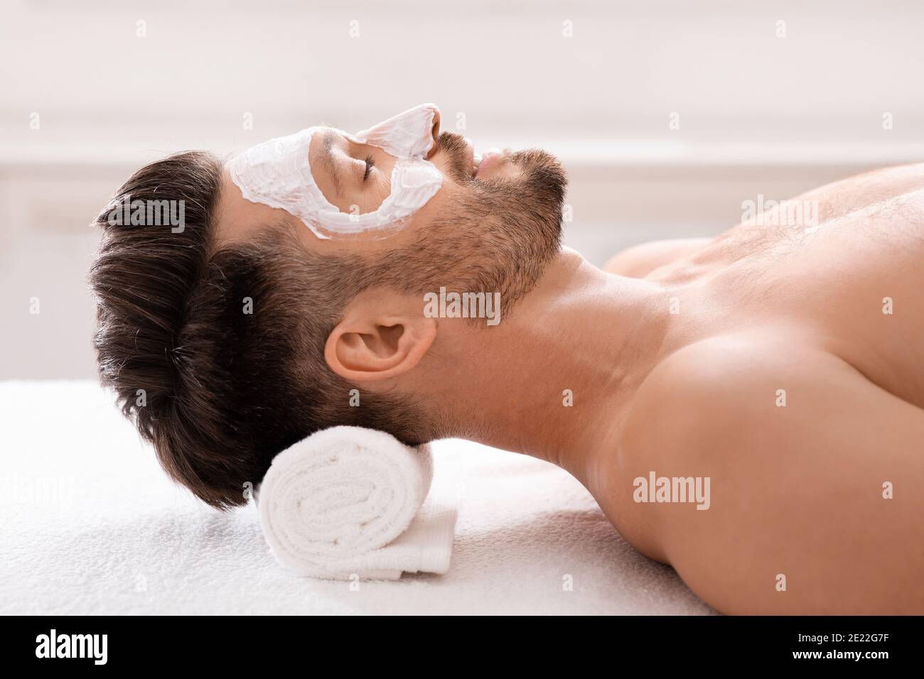 Entspannter bärtiger Mann mit weißer Gesichtsmaske Stockfoto