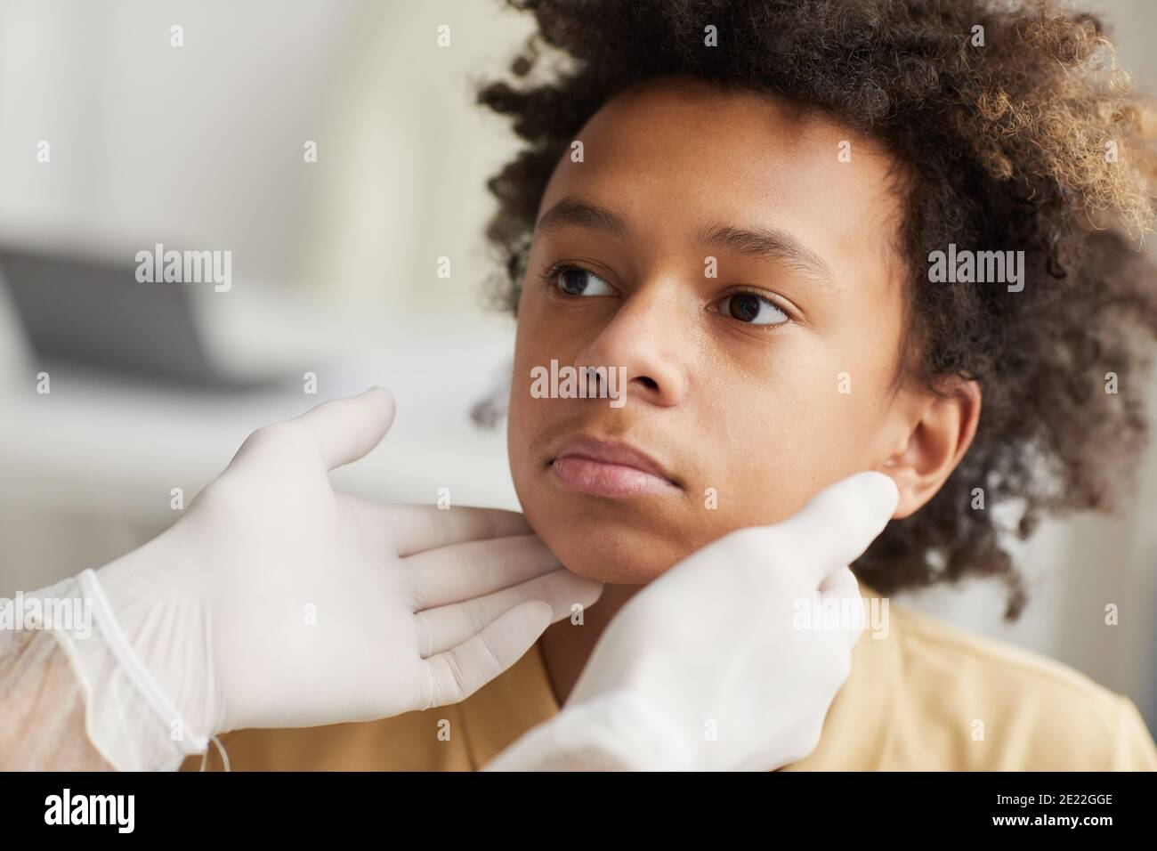 Nahaufnahme Porträt von unkenntlichen Arzt Untersuchung Hals der afroamerikanischen Junge während der Konsultation in der Klinik Stockfoto