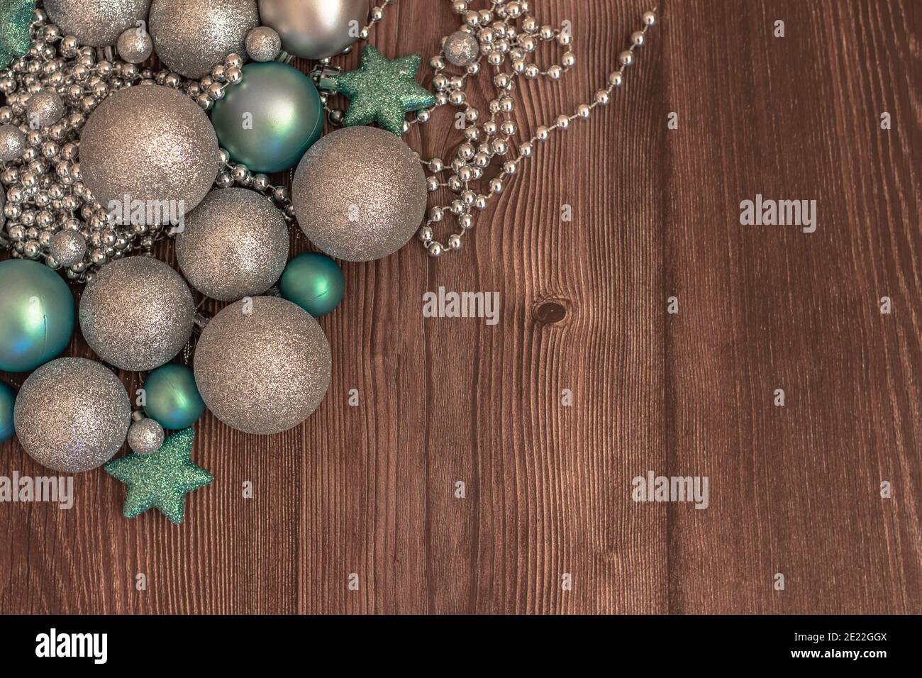 Festlicher Geschenkgutschein Hintergrund. Weihnachtsferien Komposition auf braunem Holzhintergrund mit Platz für Ihre Texte.Silber glänzende Kugeln. Festlich Stockfoto