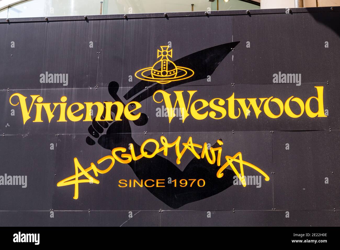 Nahaufnahme des Logos über dem Geschäft des Vivienne Westwood Anglomania-Logos auf seinem Flagship-Store in Harujuku. Tokio. Gelbe Buchstaben auf Schwarz. Stockfoto