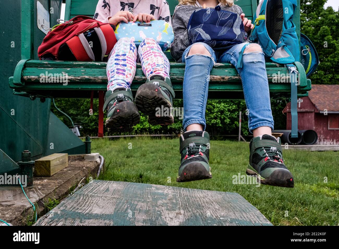 Nahaufnahme der Mädchen Füße sitzen zusammen auf Stuhl ruhen Stockfoto