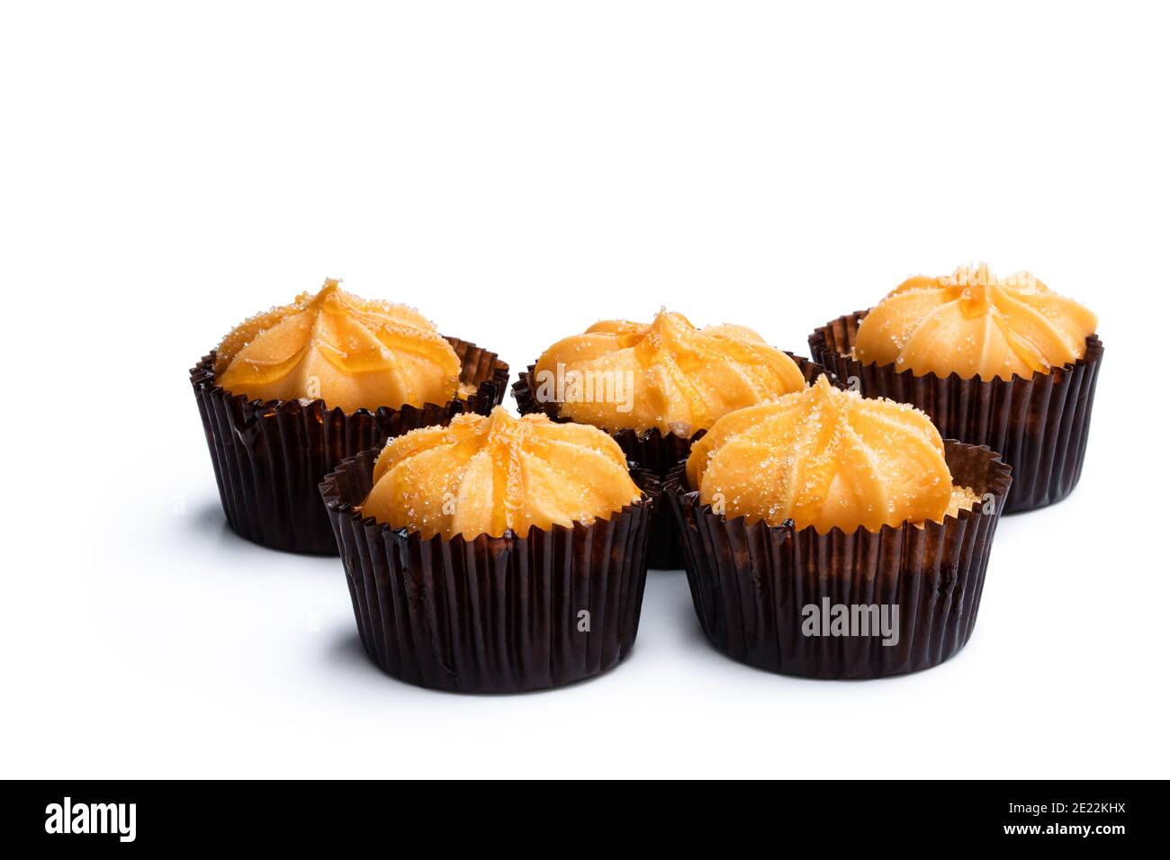 Mini-Biskuit-Kuchen mit orange Buttercreme gekrönt isoliert auf weiß Stockfoto