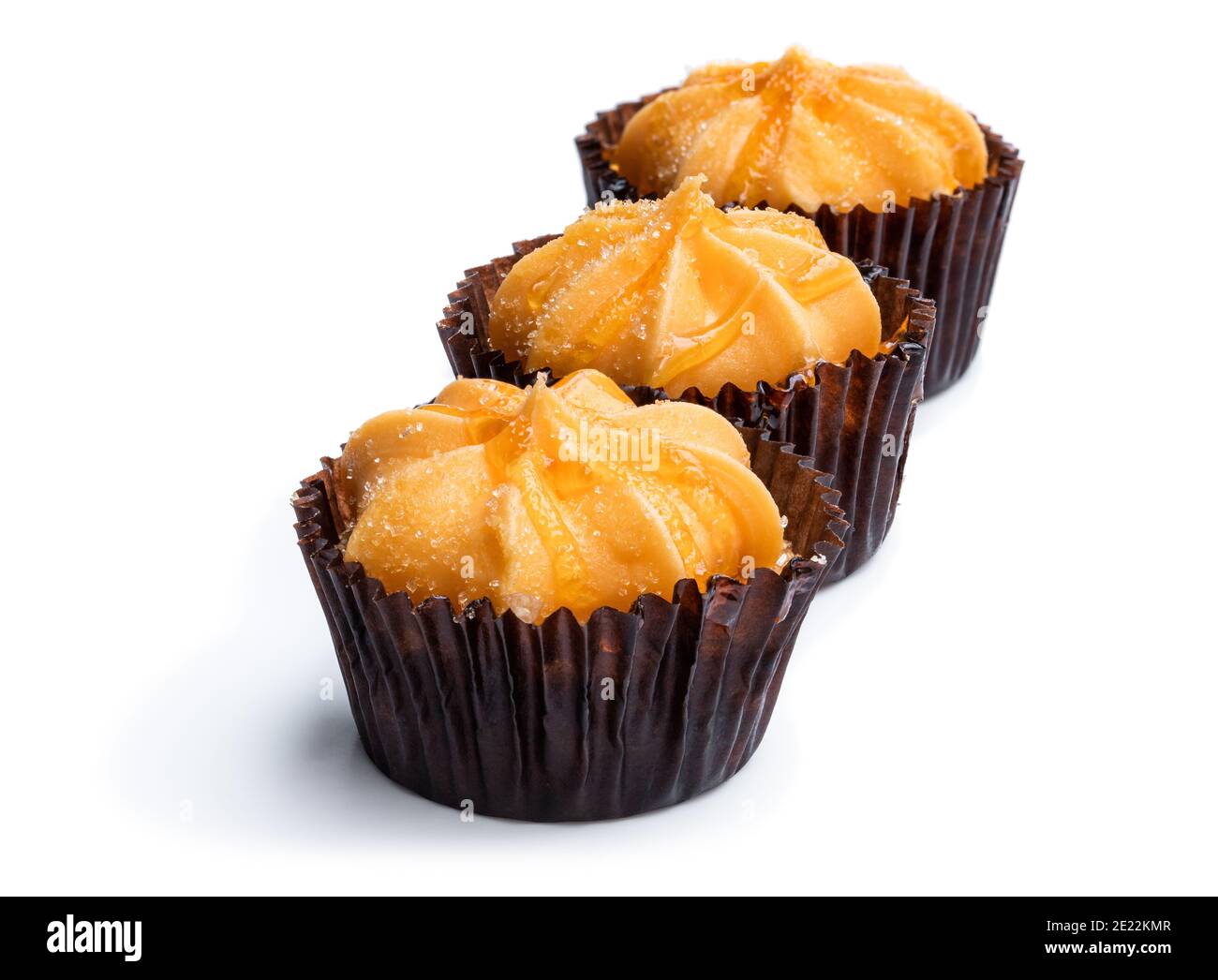 Mini-Biskuit-Kuchen mit orange Buttercreme gekrönt isoliert auf weiß Stockfoto