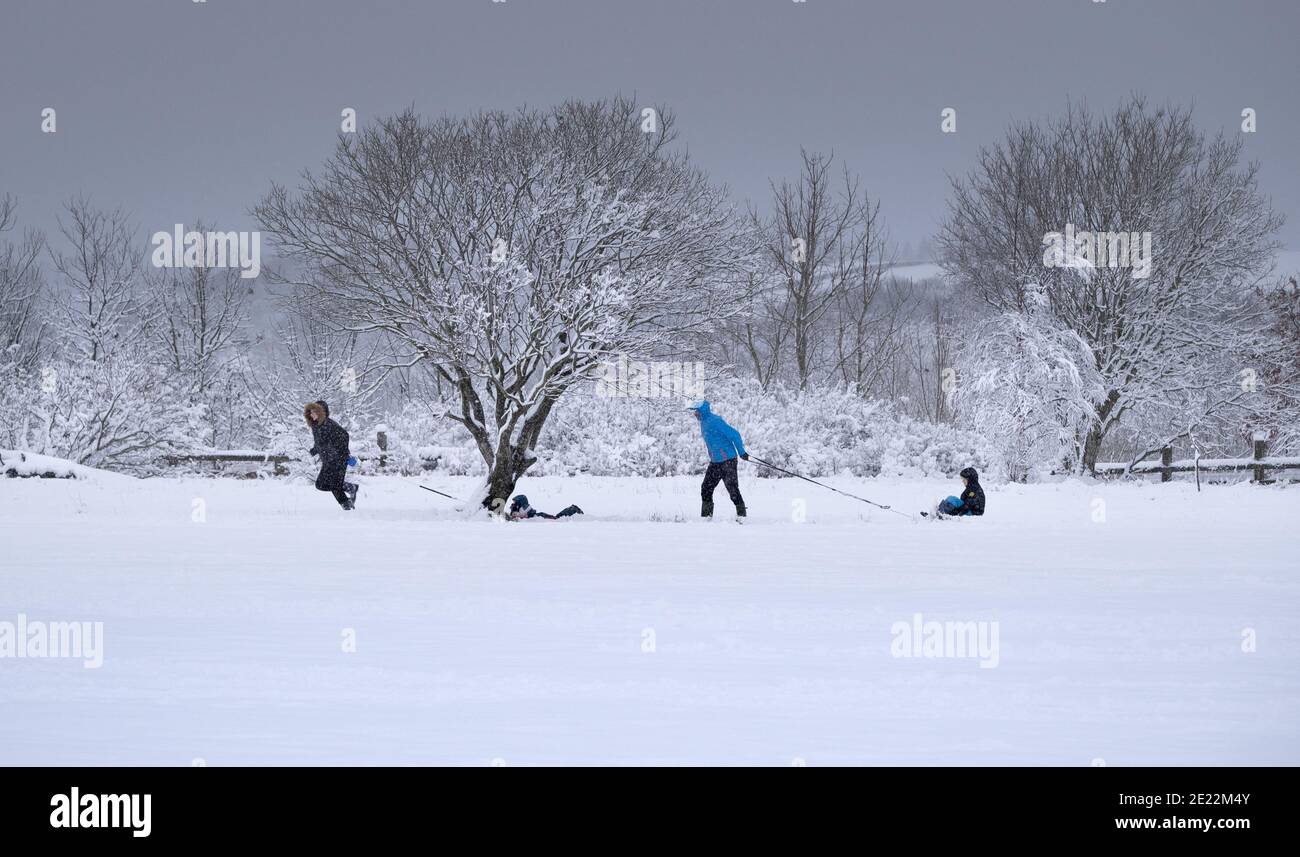 Winterspaß im Freien, Aktivitäten und Bewegung. Familien mit Kindern Rodeln im Tiefschnee. Stockfoto