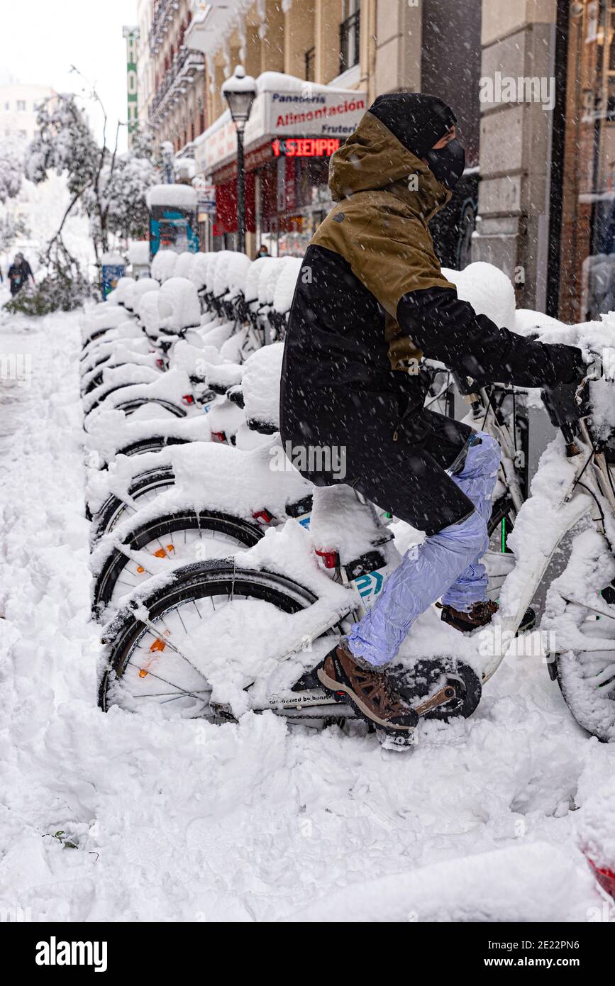 Spanien, Madrid; 9. Januar 2021: Schneesturm 'Filomena' in der Madrider Innenstadt in der Gran Via und ein Mann auf dem Fahrrad Stockfoto