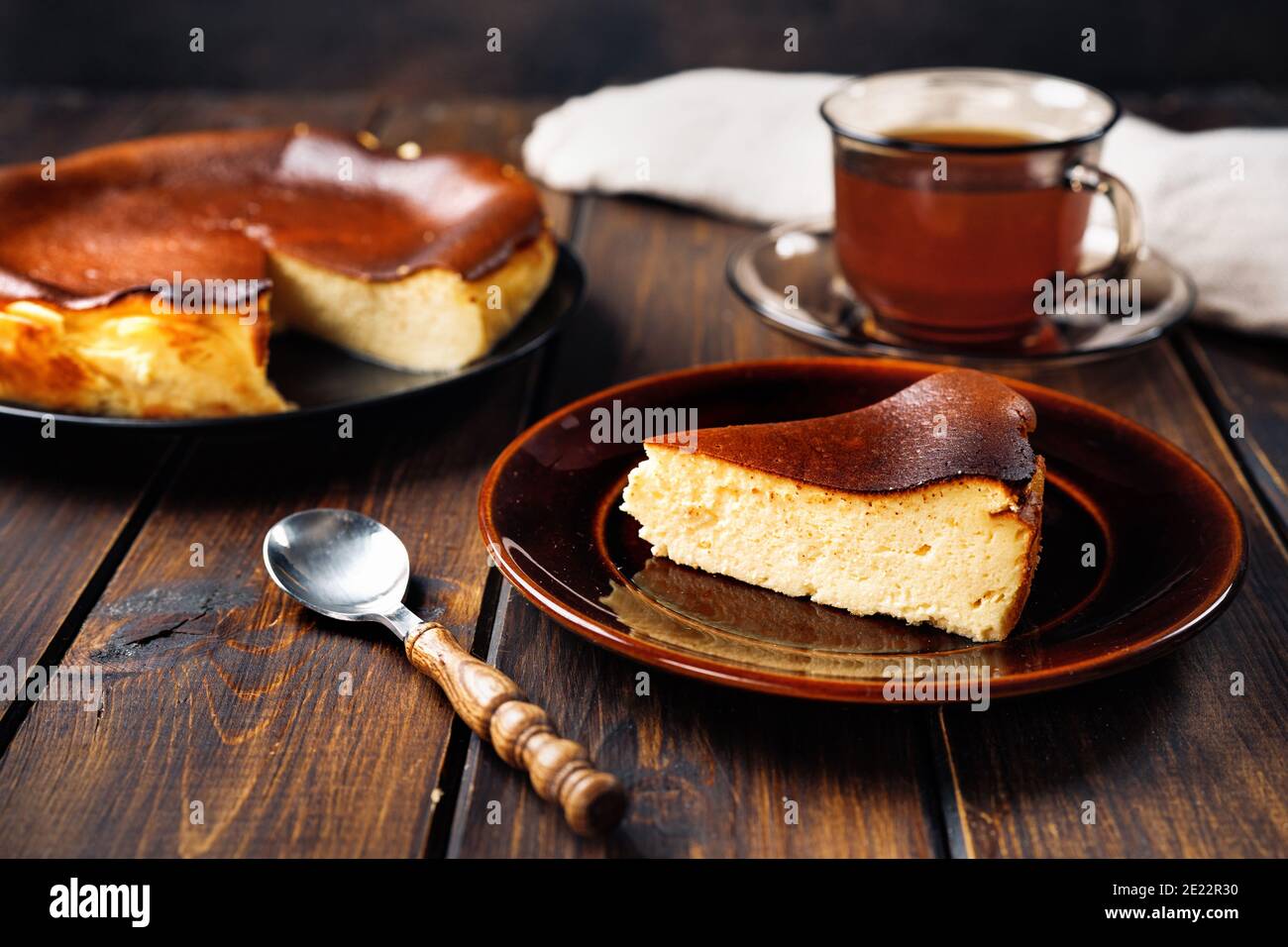 Ein Stück köstlichen baskischen gebrannten Käsekuchen mit Tasse Tee Stockfoto