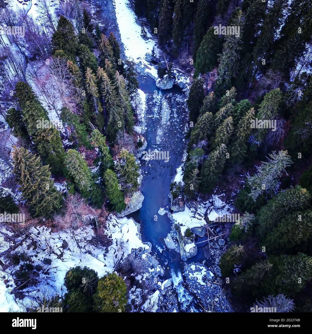 Blick von oben auf einen Bergfluss in der Taiga. Der Bergfluss im Wald im Winter. Stockfoto