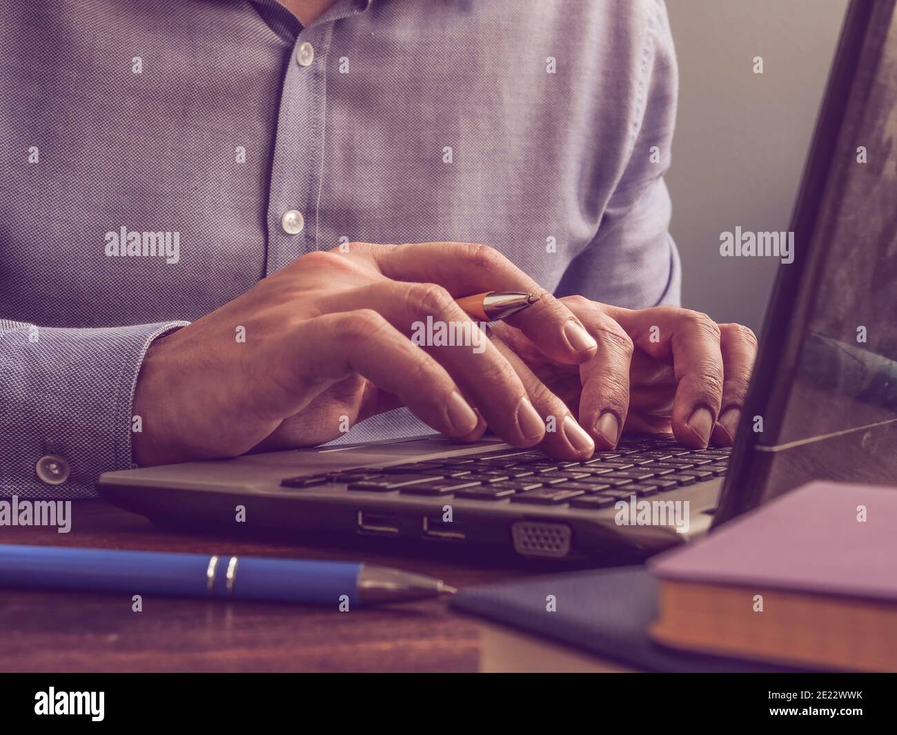 Blogger schreibt Text in einem Laptop. Der Mann tippt auf der Tastatur. Stockfoto