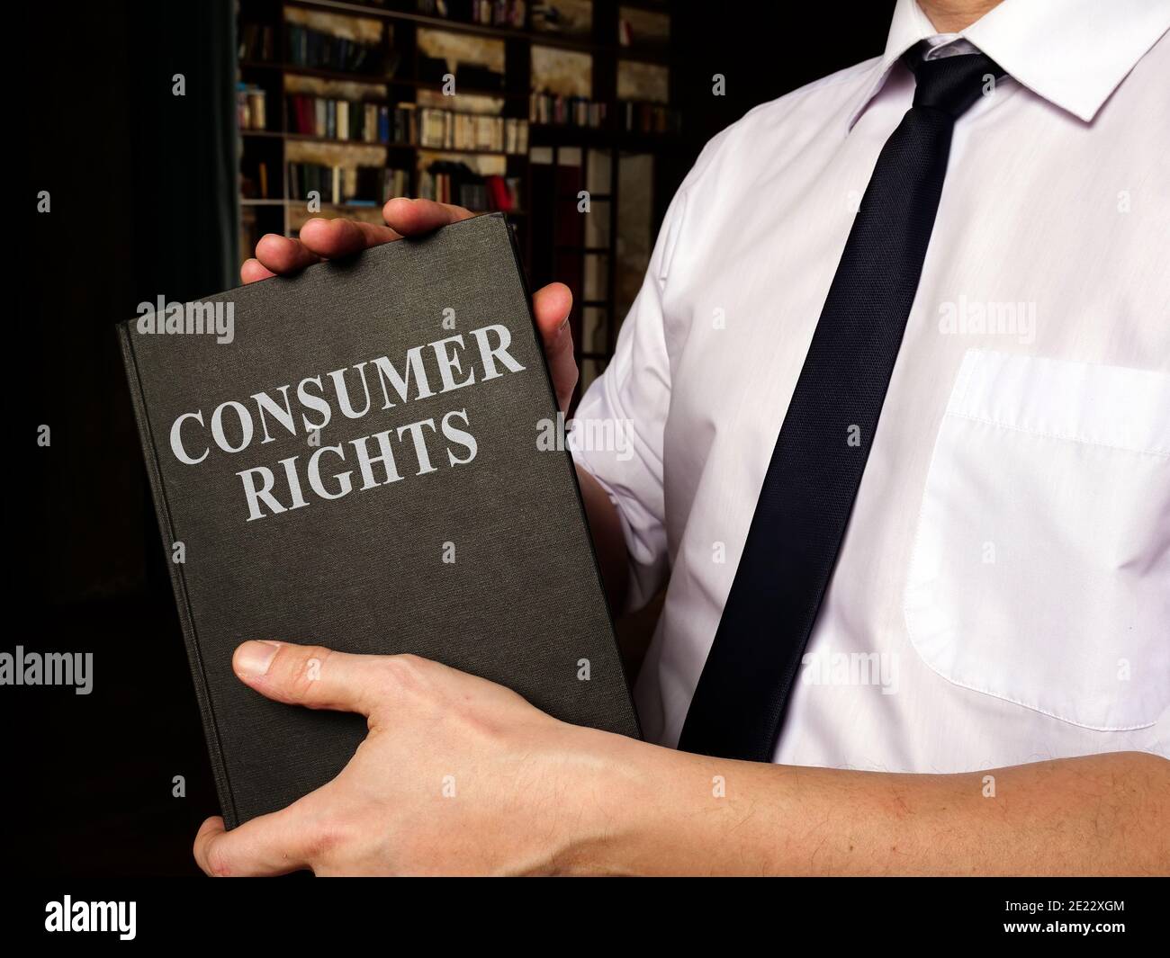 Ein Manager schlägt Buch Verbraucherrechte in seinem Büro vor. Stockfoto