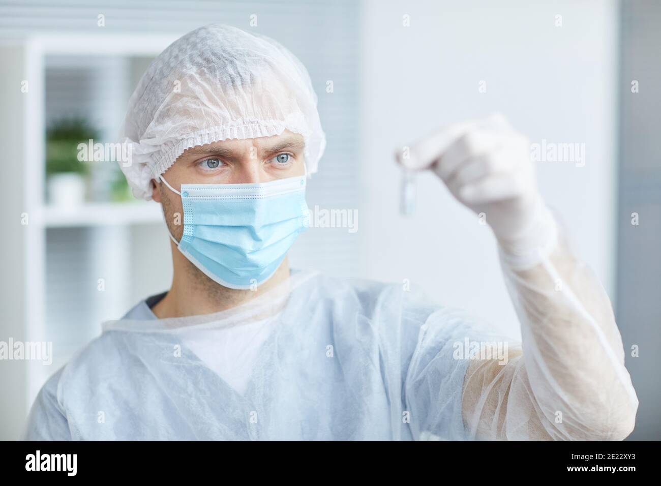 Portrait der männlichen Krankenschwester trägt Maske und Schutzkleidung mit Ampulle mit Medizin während der Arbeit in der Klinik oder Krankenhaus, kopieren Raum Stockfoto