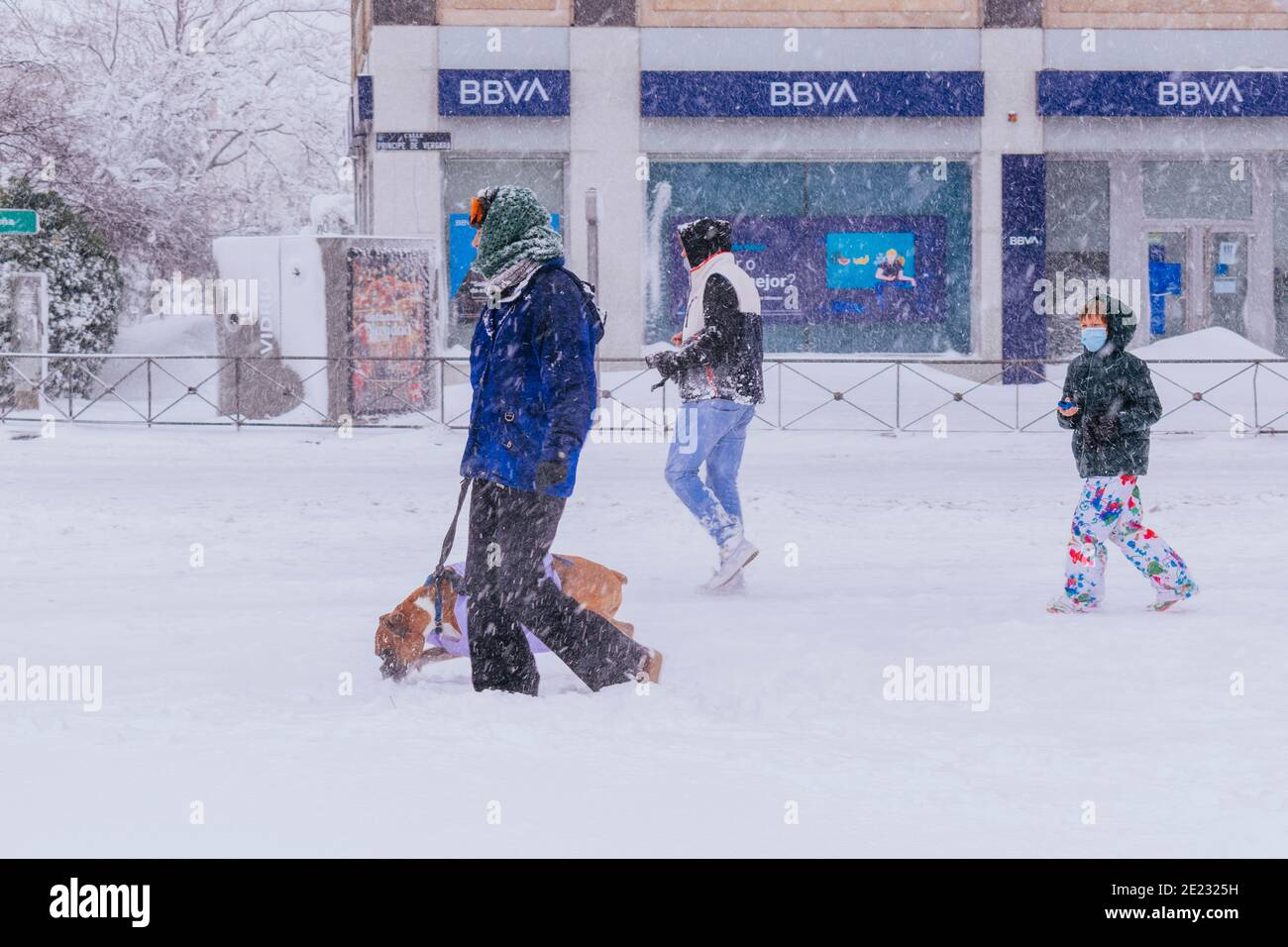 Leute, die eine verschneite Straße entlang laufen, unmöglich für den Autoverkehr. Filomena starker Schneefall. Madrid, Spanien Stockfoto