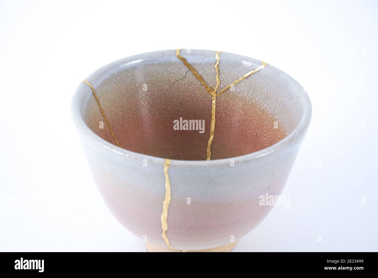 Japanische Kintsugi beige Teetasse, Goldrisse auf antike Keramik. Stockfoto