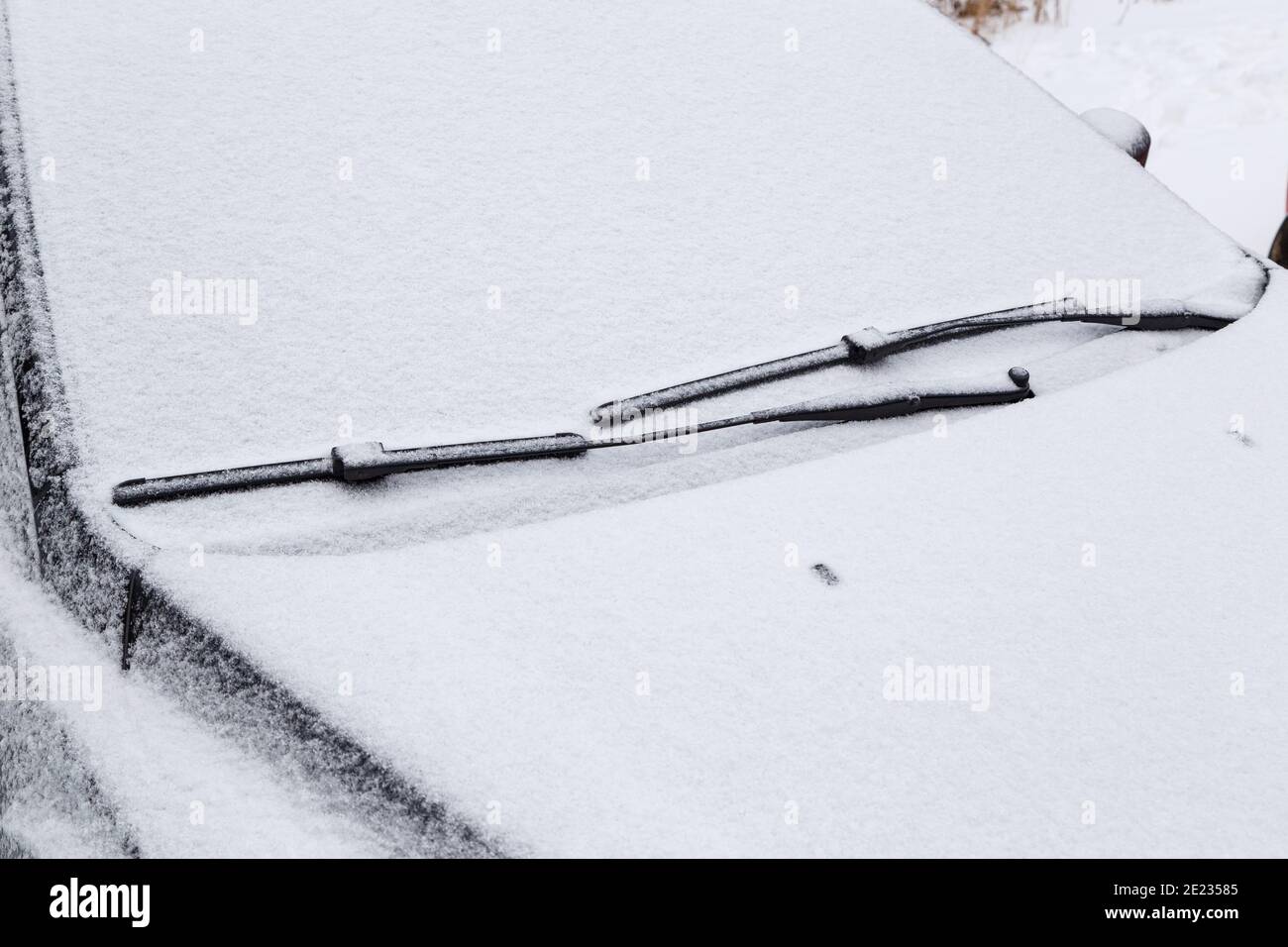 Windschutzscheibe und Scheibenwischer, die bei bewölktem Winterwetter  gefroren und mit Schnee bedeckt sind Stockfotografie - Alamy