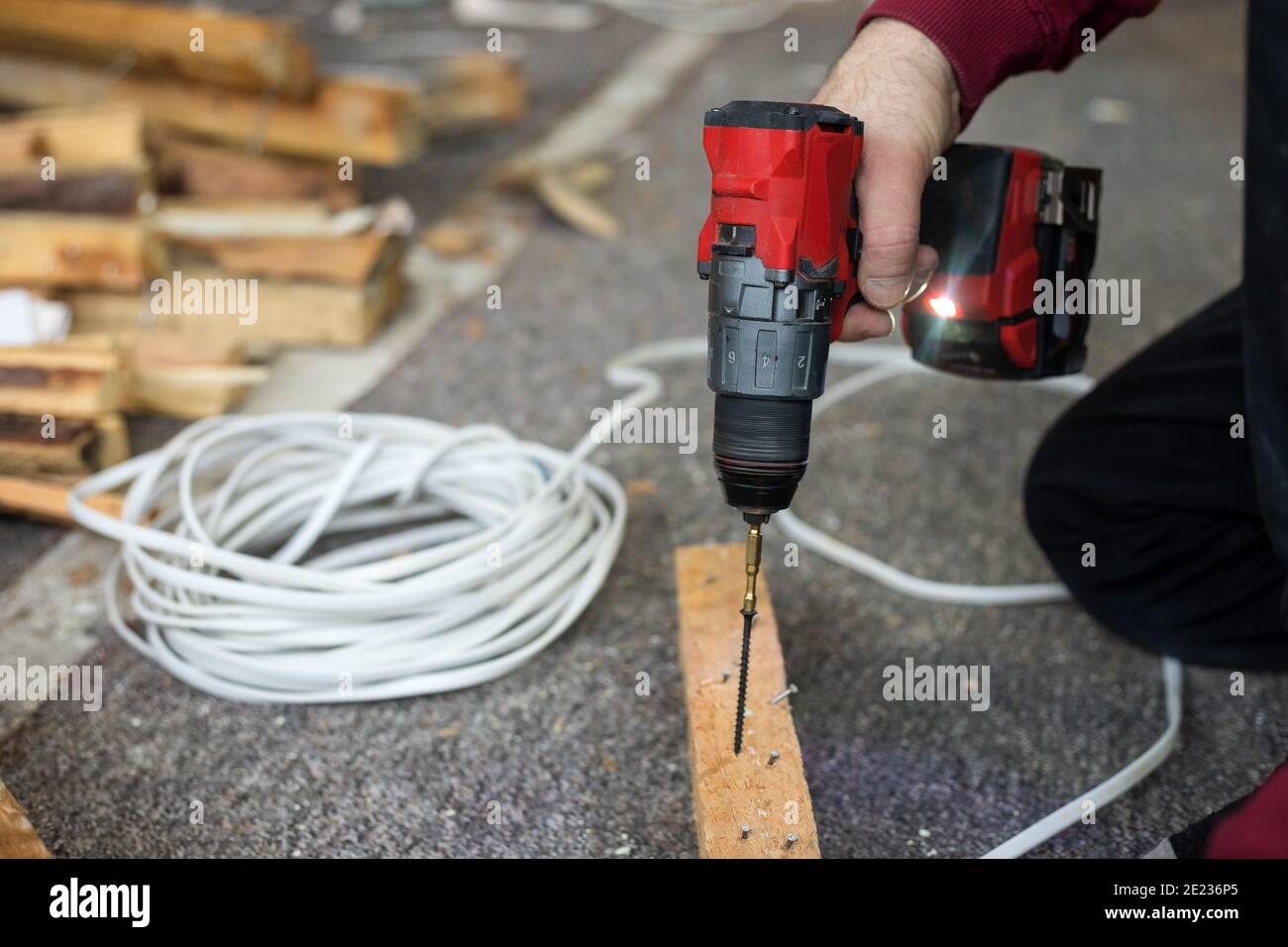 Männliche Hände verwenden Schraubendreher bei Bauarbeiten mit Holz in Innenräumen. Lifestyle-Foto Stockfoto
