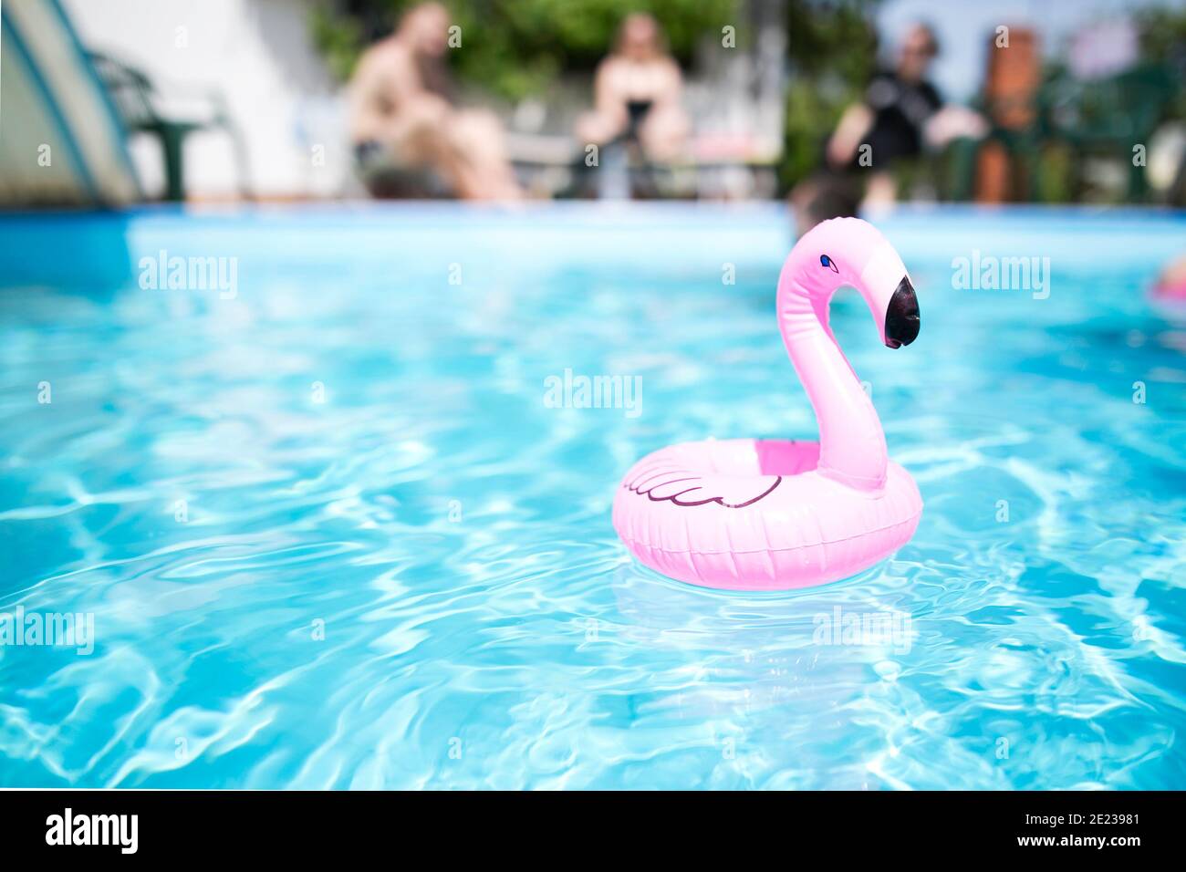 Rosa Flamingo Cup Halter Schwimmbad Sommer helle Farben kopieren Raum verschwommen Menschen im Hintergrund Pool Party Stockfoto