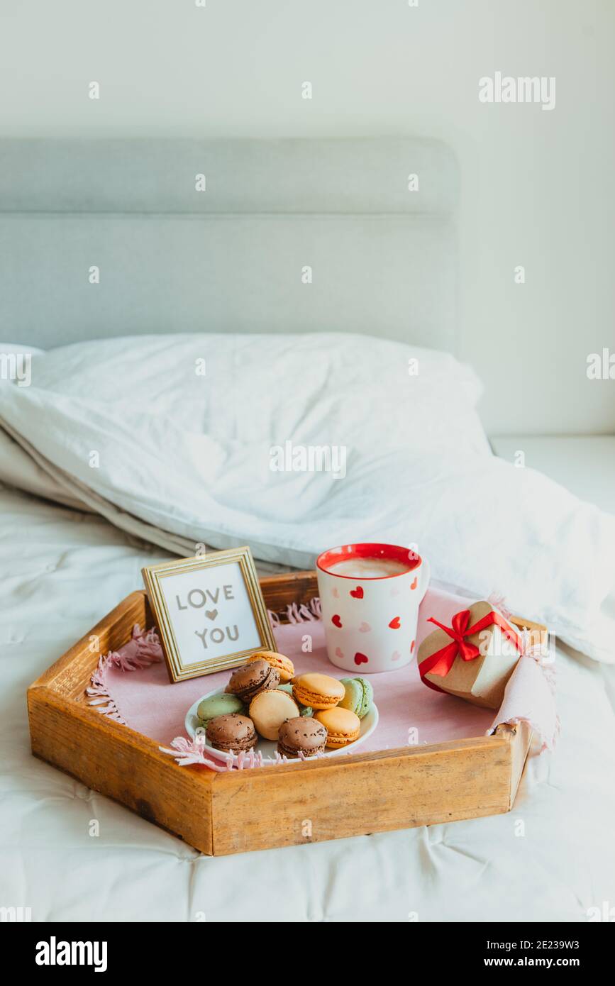 Valentinstag Frühstück im Bett für Liebhaber. Love You Karte im Rahmen,  eine Tasse Kaffee oder Kakao, Makronen, herzförmige Geschenkbox mit rotem  Band auf Stockfotografie - Alamy