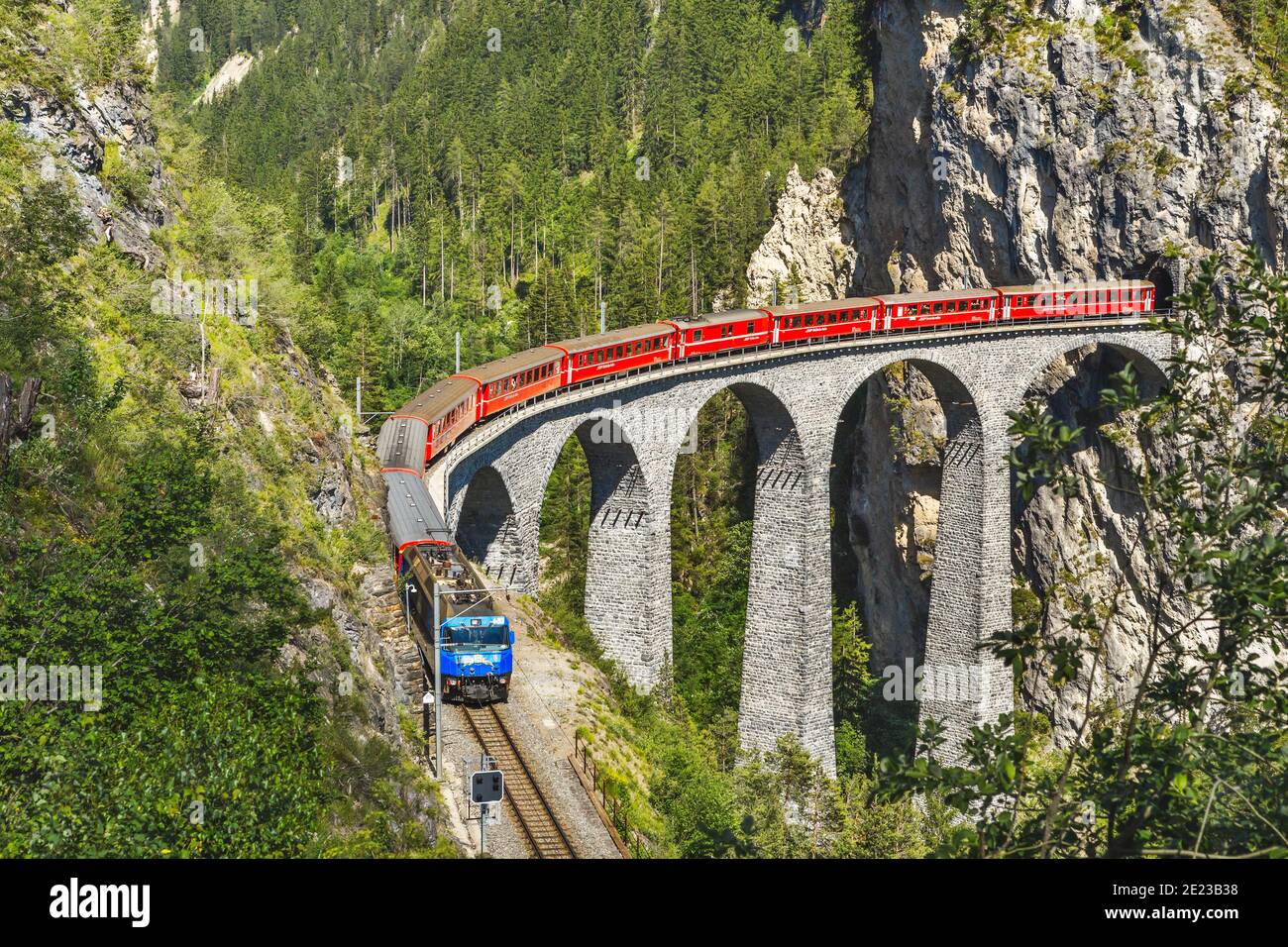 Landwasser Viadukt in Filisur, Schweiz. Es ist ein berühmtes Wahrzeichen der Schweiz. Roter Expresszug auf hoher Brücke in den Bergen. Landschaftlich schöne Aussicht auf unglaublich Stockfoto