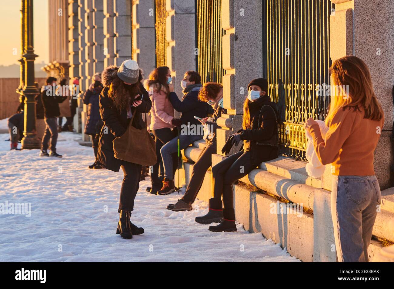 Madrid, Madrid, Spanien. Januar 2021. Blick auf den Königspalast mit einem großen weiten Schneeplatz bei Sonnenuntergang mit Menschen fotografieren und genießen Sie mit Schneelandschaft am 11. Januar 2021 in Madrid, Spanien. Storm Filomena brachte mehr als 50 cm Schnee in die spanische Hauptstadt, der meiste seit Jahrzehnten. Kredit: Jack Abuin/ZUMA Wire/Alamy Live Nachrichten Stockfoto
