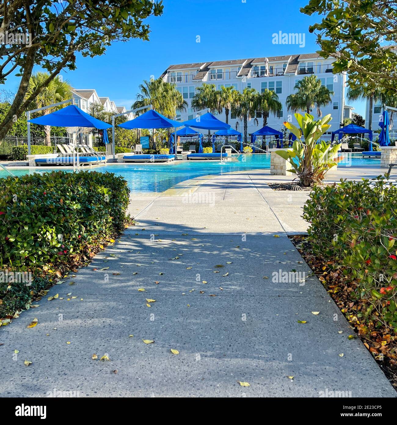 Orlando, FL USA - 4. Januar 2021: Ein Nachbarschaftskomplex Pool, der wie ein Resort mit Palmen, Wasserstrahlen und Cabanas aussieht. Stockfoto