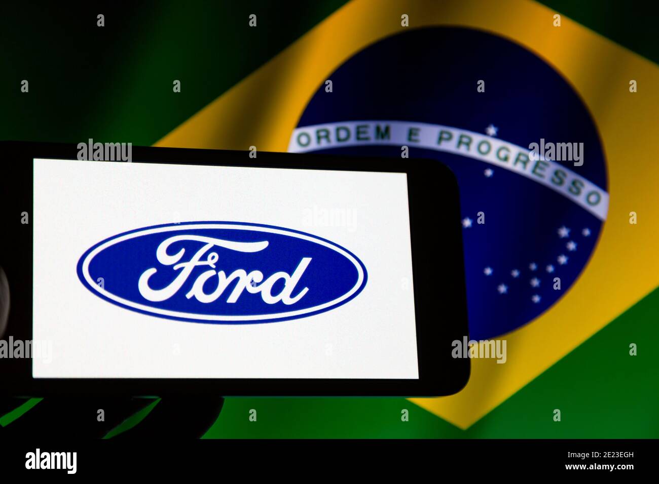 Asuncion, Paraguay. Januar 2021. Abbildung Foto - Logo Der Ford Motor  Company, Einem Amerikanischen Multinationalen Unternehmen Mit Sitz In  Dearborn, Michigan, Wird Auf Einem Smartphone-Bildschirm Zurückgelassen Von  Abgeschnitten Winkende Flagge ...
