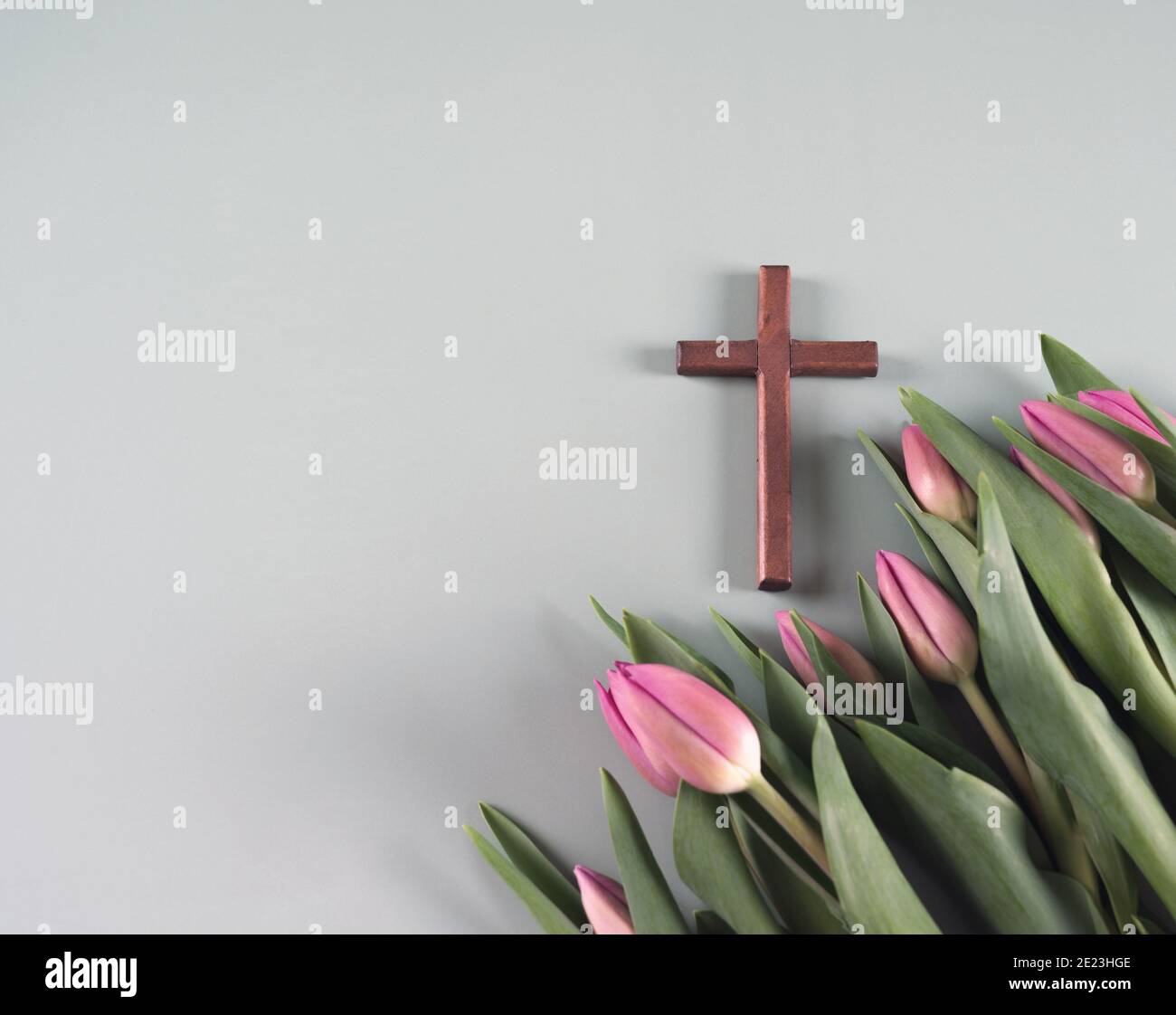 Holzkreuz und frische Frühlingsblumen. Auferstehungszeit. Kirchenkonzept. Draufsicht. Kopierbereich. Stockfoto