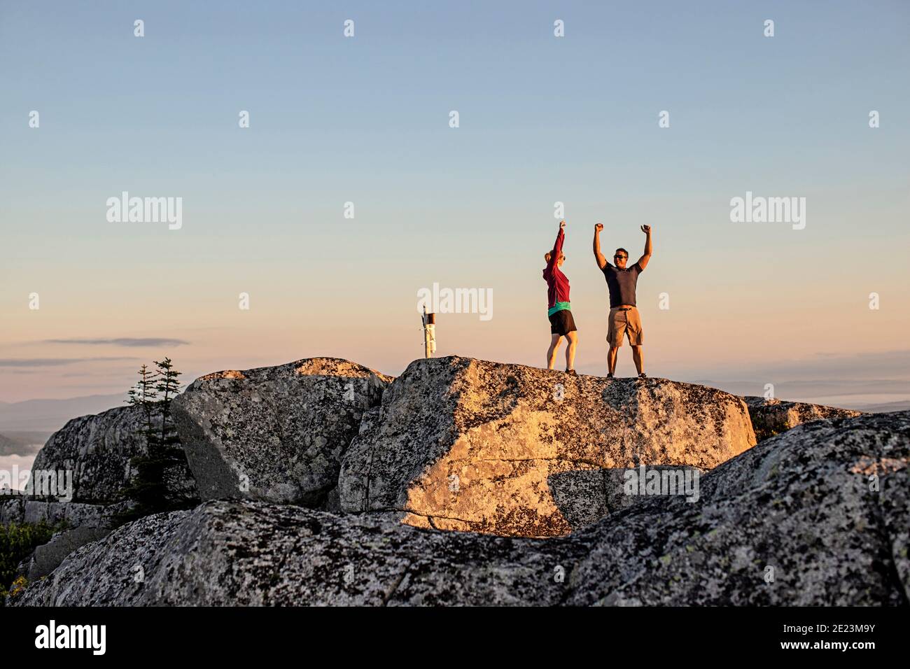 Mann und Frau feiern das Erreichen des Berggipfels beim Wandern, Maine Stockfoto