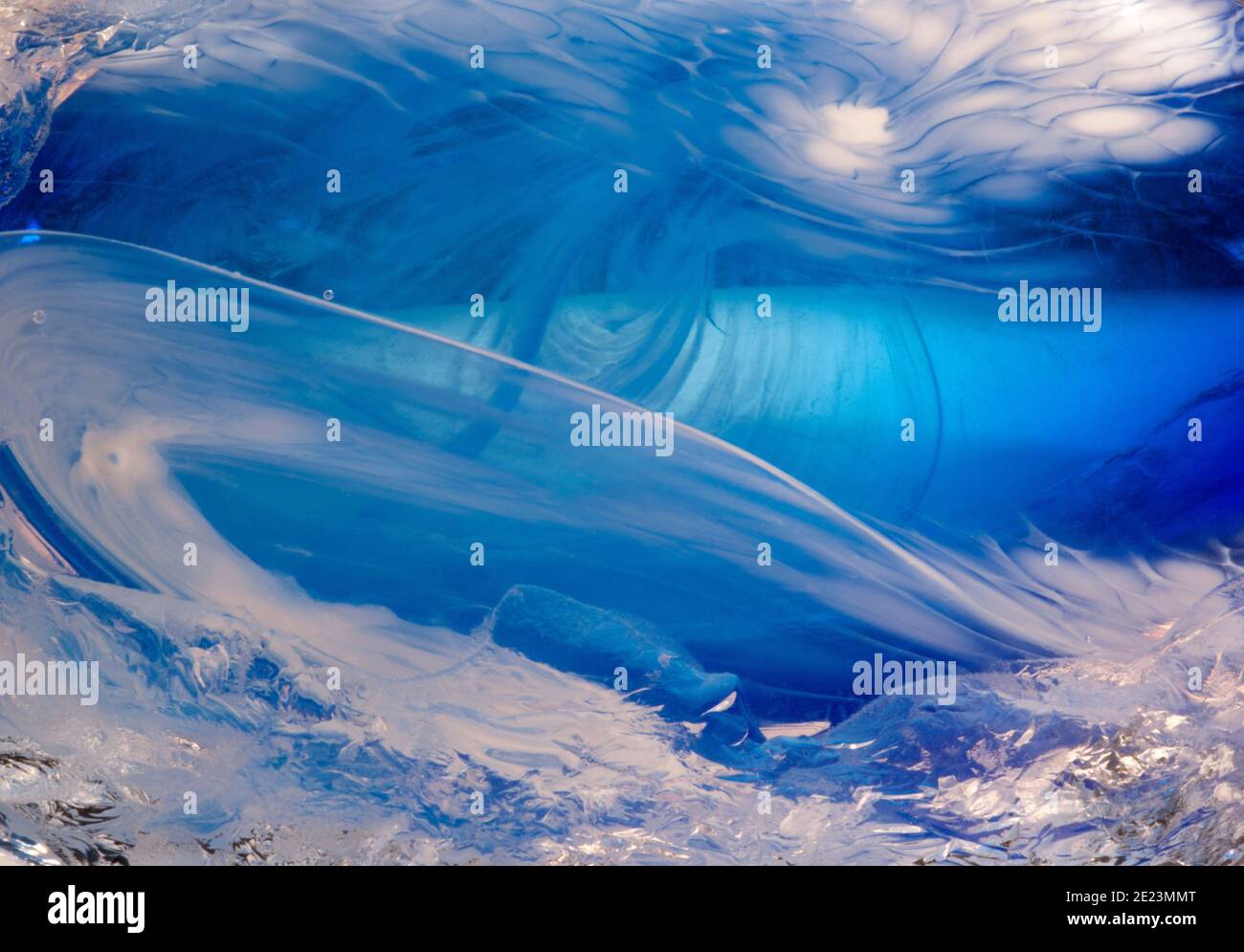 Nahaufnahme Makro-Fotografie von komplizierten fließenden Mustern in einer handgefertigten, mundgeblasenen blauen und weißen Glasvase. Stockfoto