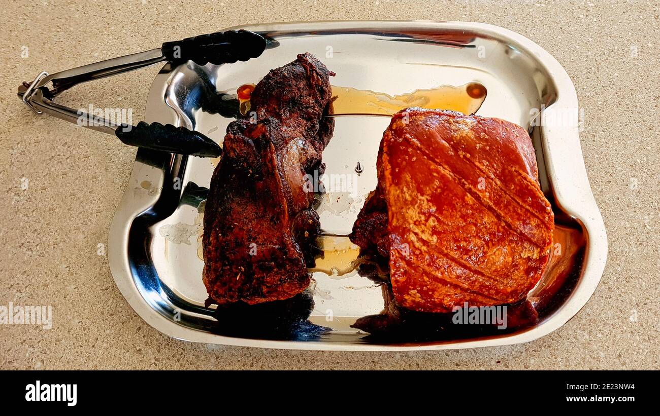 Gebratenes Lamm und Schweinebraten auf Carving-Tablett Stockfoto