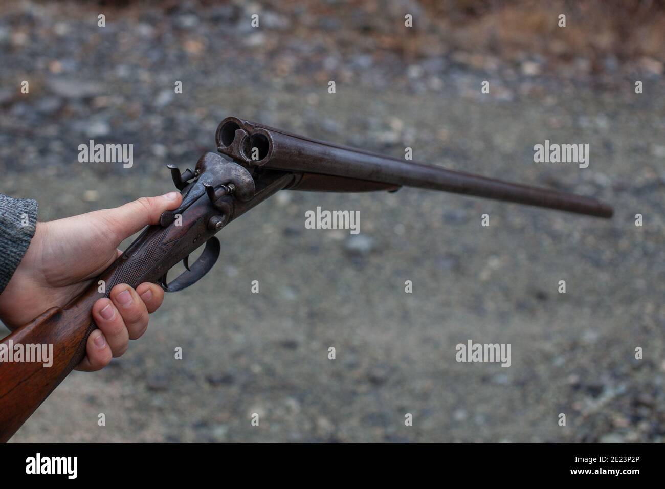 Ein Mann hält eine alte, antike, Doppel-Lauf-Break-Action-Schrotflinte, bereit, zwei Runden in die Bohrung zu laden. Outdoor-Bereich in Squamish, British-Columb Stockfoto