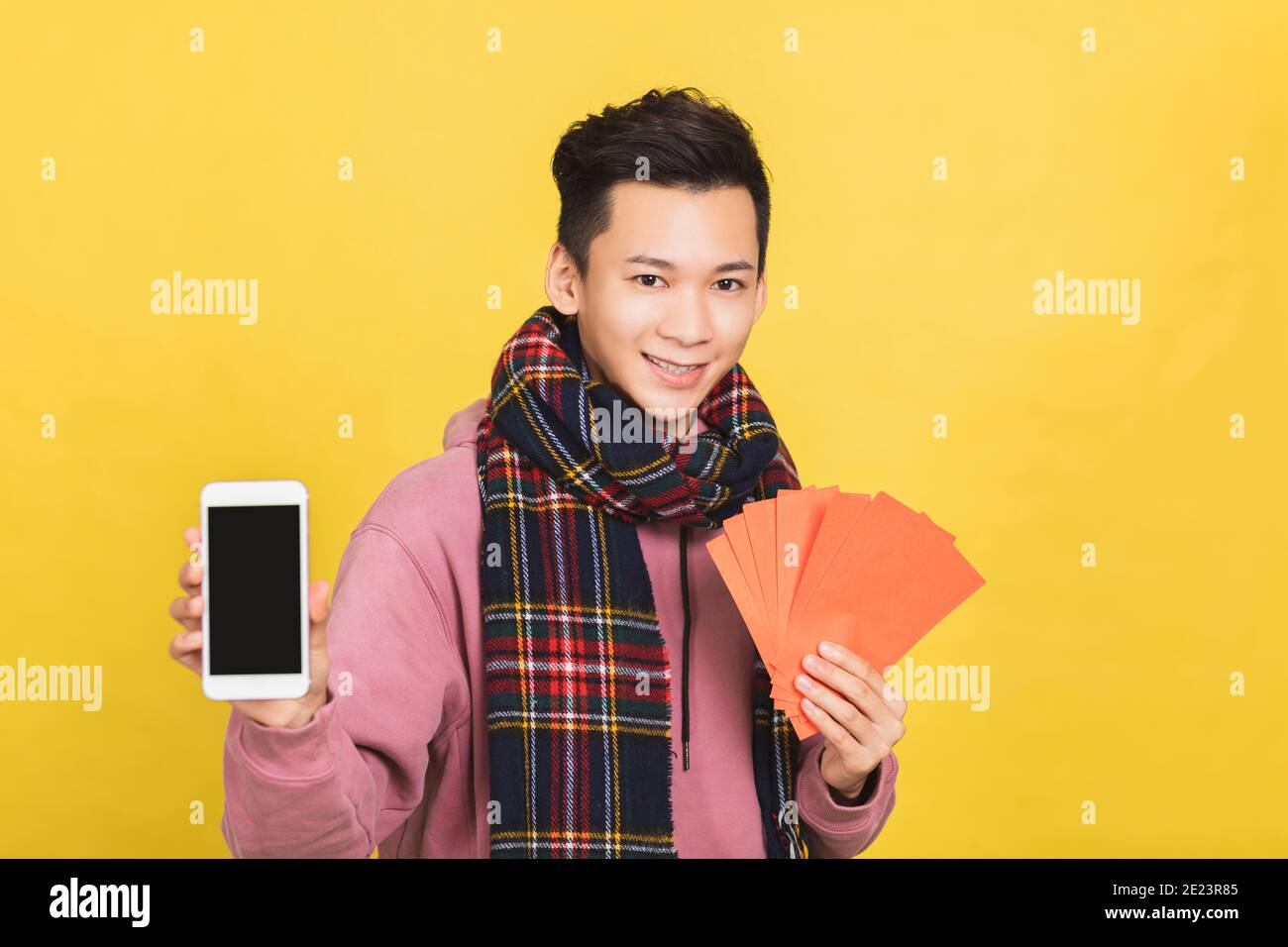 asiatischer Mann zeigt rote Envelpoe und Handy-Bildschirm, feiert chinesischen Neujahrskonzept Stockfoto