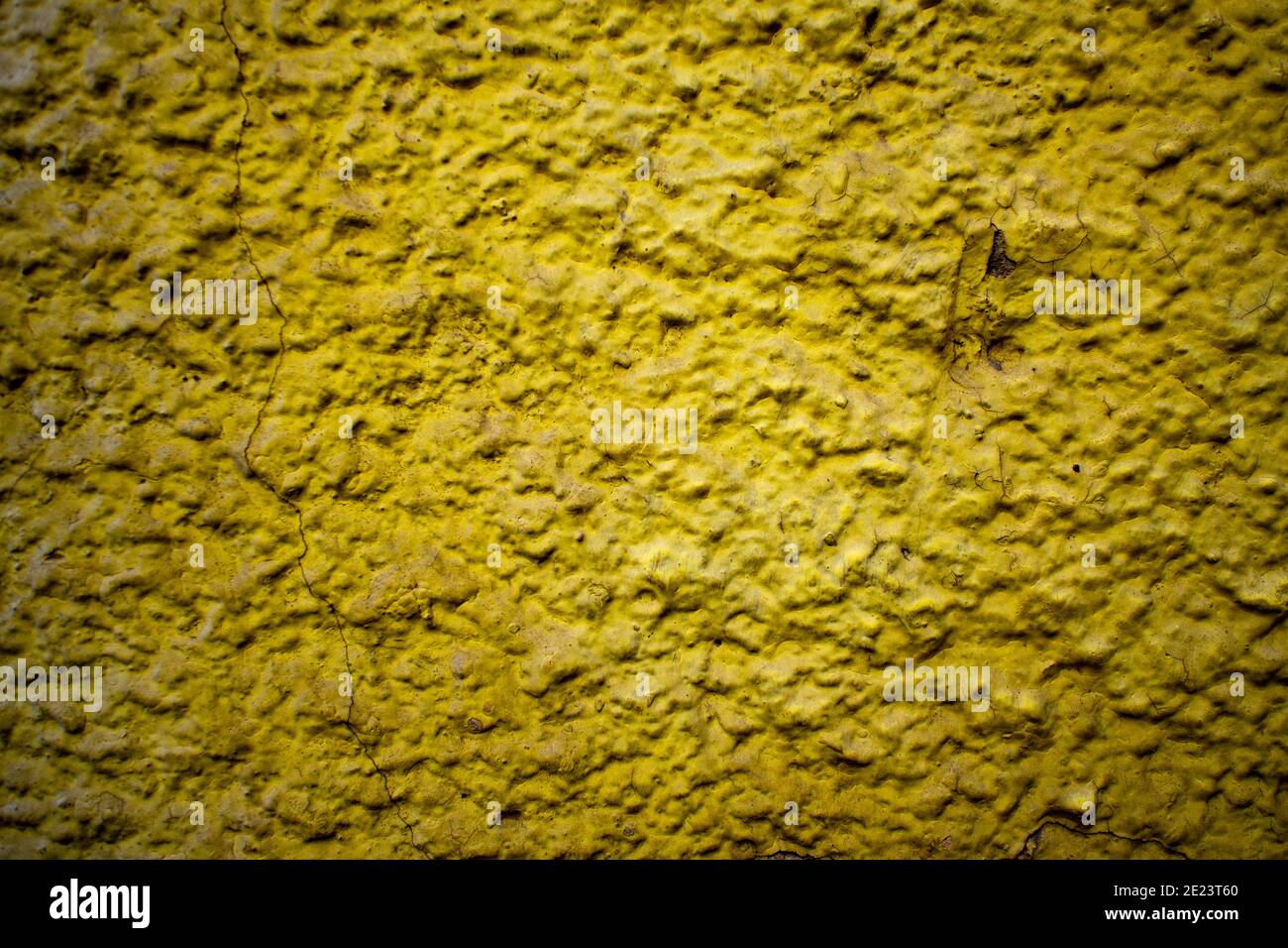 Strukturierte Wand mit abblätternder gelber Farbe. Altes Gebäude. Schöner abstrakter Hintergrund. Stockfoto