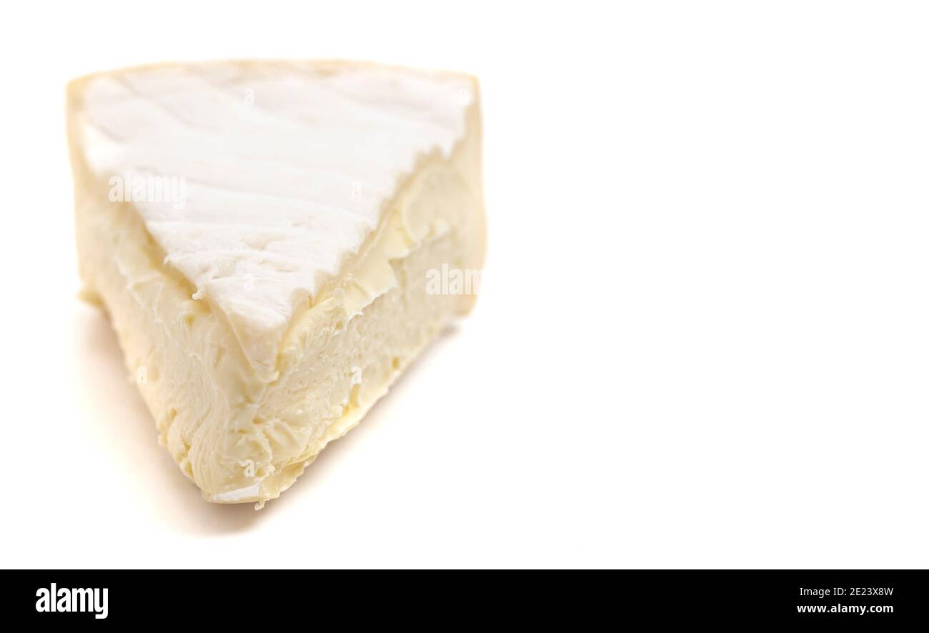 Dreiecksschnitt eines weichen weißen Käses mit einer Rine Isoliert auf weißem Hintergrund Stockfoto