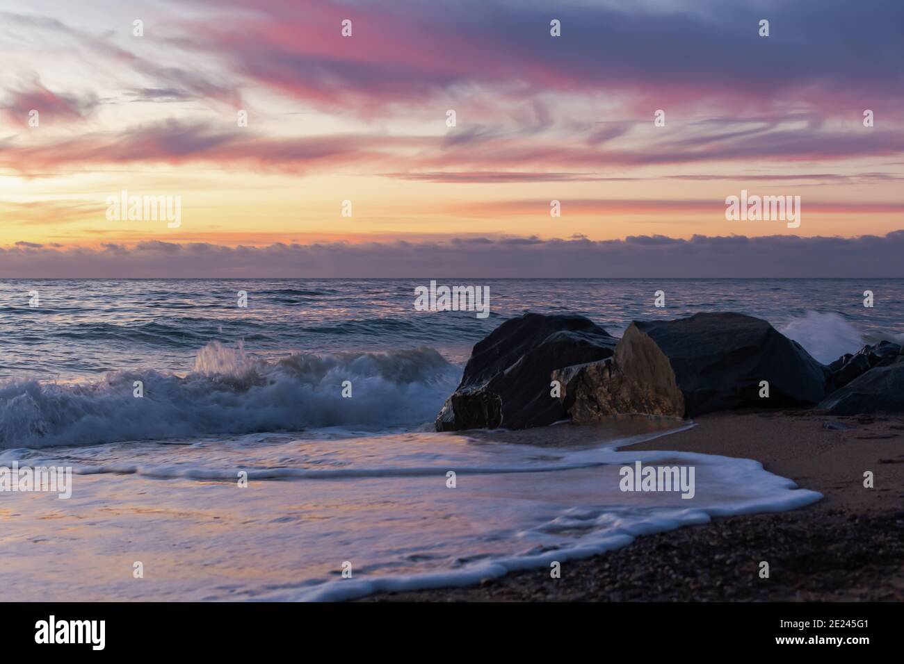 Lila Sonnenuntergang auf dem Meer. Helle stimmungsvolle Landschaft in violetten Farbtönen. Natürlicher Hintergrund in der Dämmerung. Das Konzept der Entspannung und Entspannung. Stockfoto