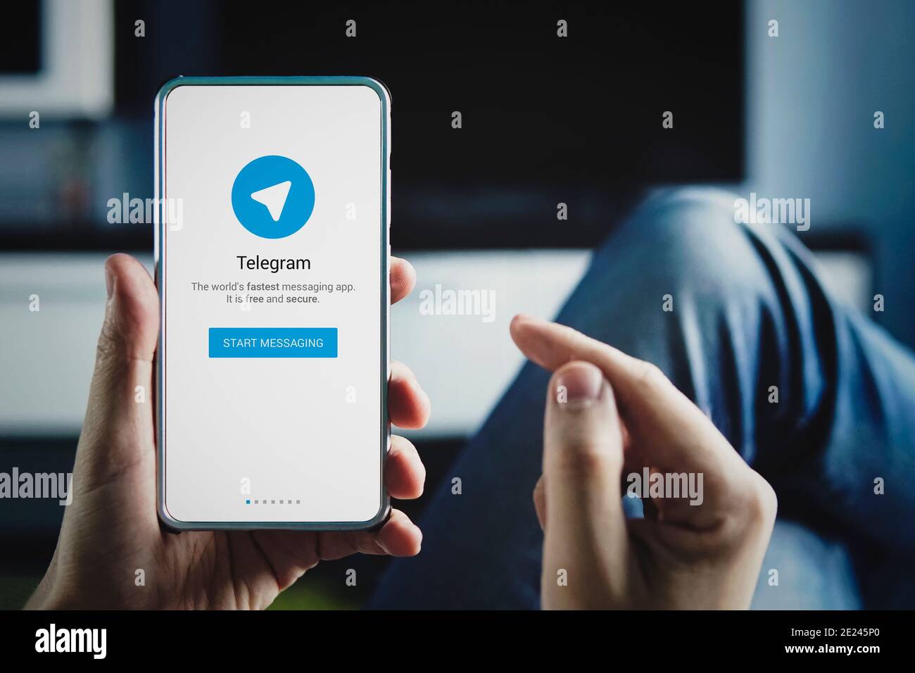 Mann hält Smartphone mit Telegram-Logo mit dem Finger auf dem Bildschirm zu Hause. Juli 22, 2018. Barnaul, Russland. Stockfoto