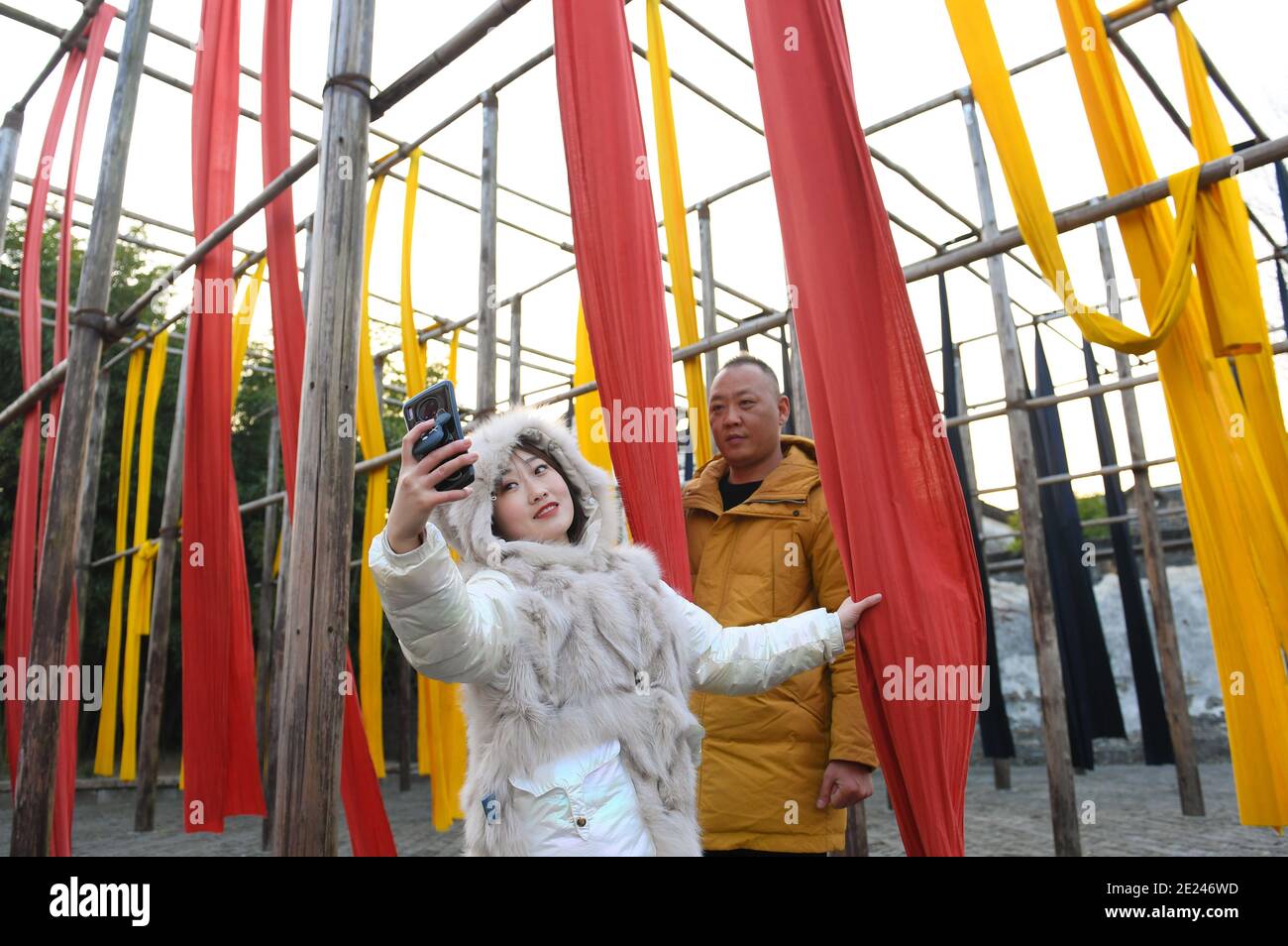 Wuzhen, Chinas Provinz Zhejiang. Januar 2021. Das am 11. Januar 2021 aufgenommene Foto zeigt Touristen, die für ein Selfie auf einem Tuchlüftungshof in Wuzhen, Ostchinas Provinz Zhejiang, am 12. Januar 2021 posieren. Quelle: Weng Xinyang/Xinhua/Alamy Live News Stockfoto