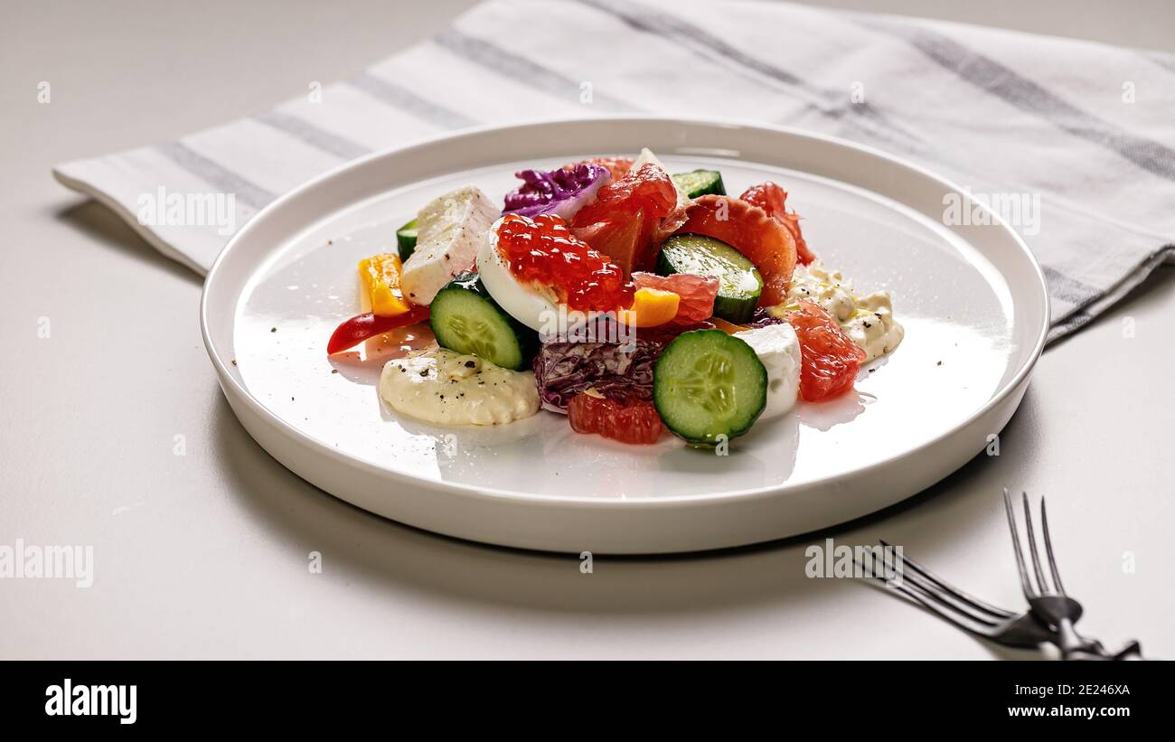 Lebensmittelbanner. Köstlicher und gesunder Salat. Geräucherte Forelle, Grapefruit, frische Gurken, purpurner Chinakohl, Ziegenkäse und Paprika. Mediterrane Stockfoto
