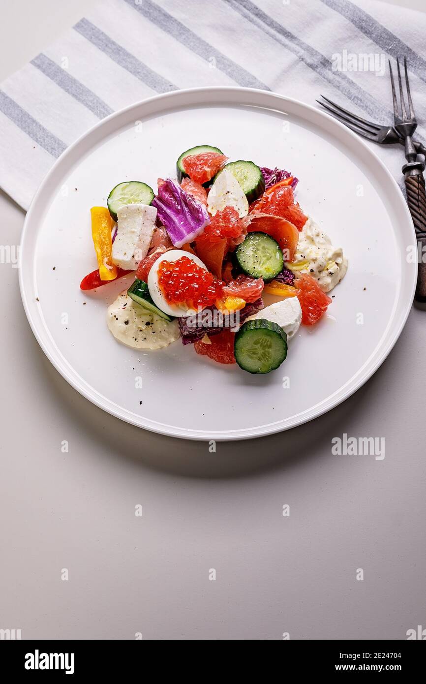 Leckere und gesunde Lebensmittel. Salat mit geräucherter Forelle, Grapefruit, frischer Gurke, purpurem Chinakohl, Ziegenkäse und Paprika. Mittelmeer Stockfoto