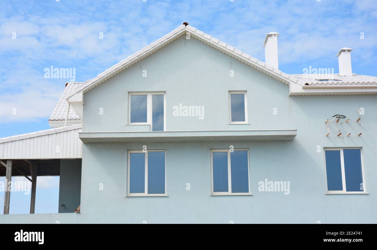 Eine hellblaue und weiße Haus Stuckfassade, Dachfenster, Außenwand Renovierung und Rendering, offene Balkon Rekonstruktion mit einer Klimaanlage. Stockfoto