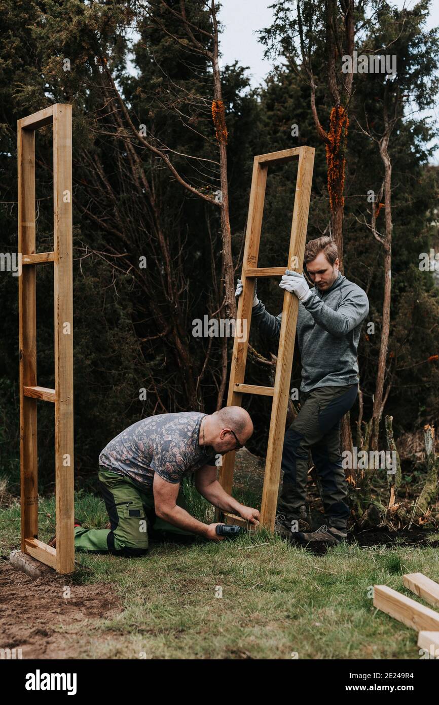 Männer setzen Holzrahmen auf Stockfoto